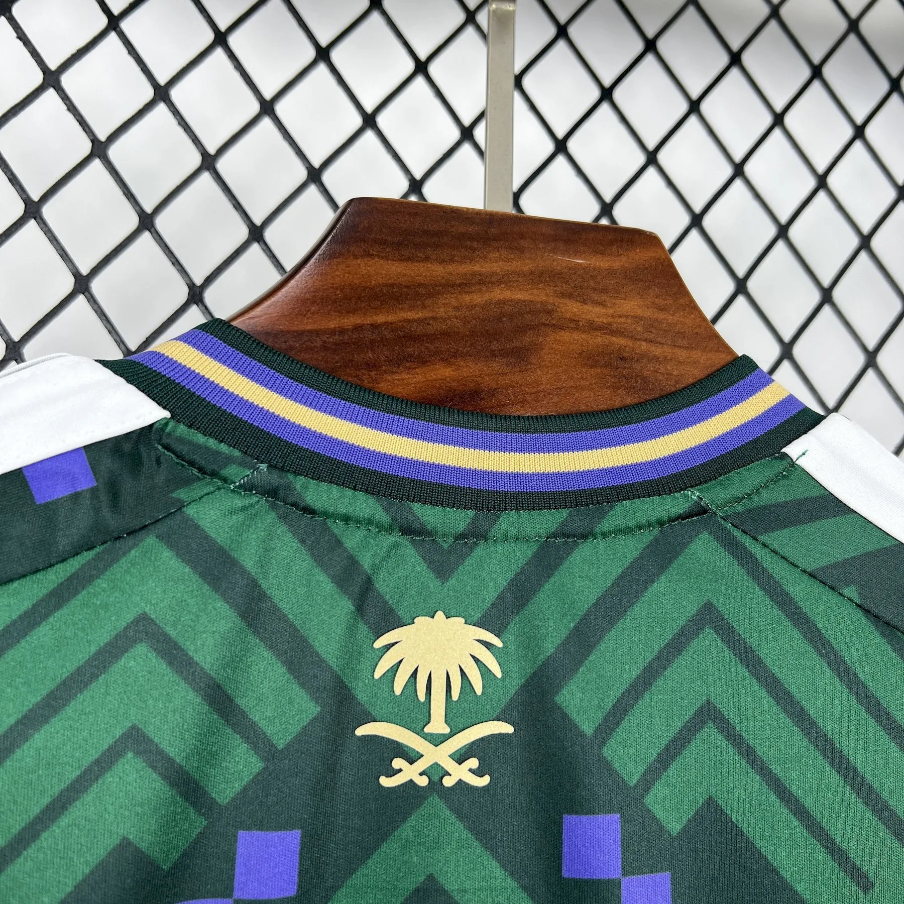 Detalle del interior del cuello redondo con ribetes amarillos y morados de la camiseta de Arabia Saudita para el Mundial 2026.