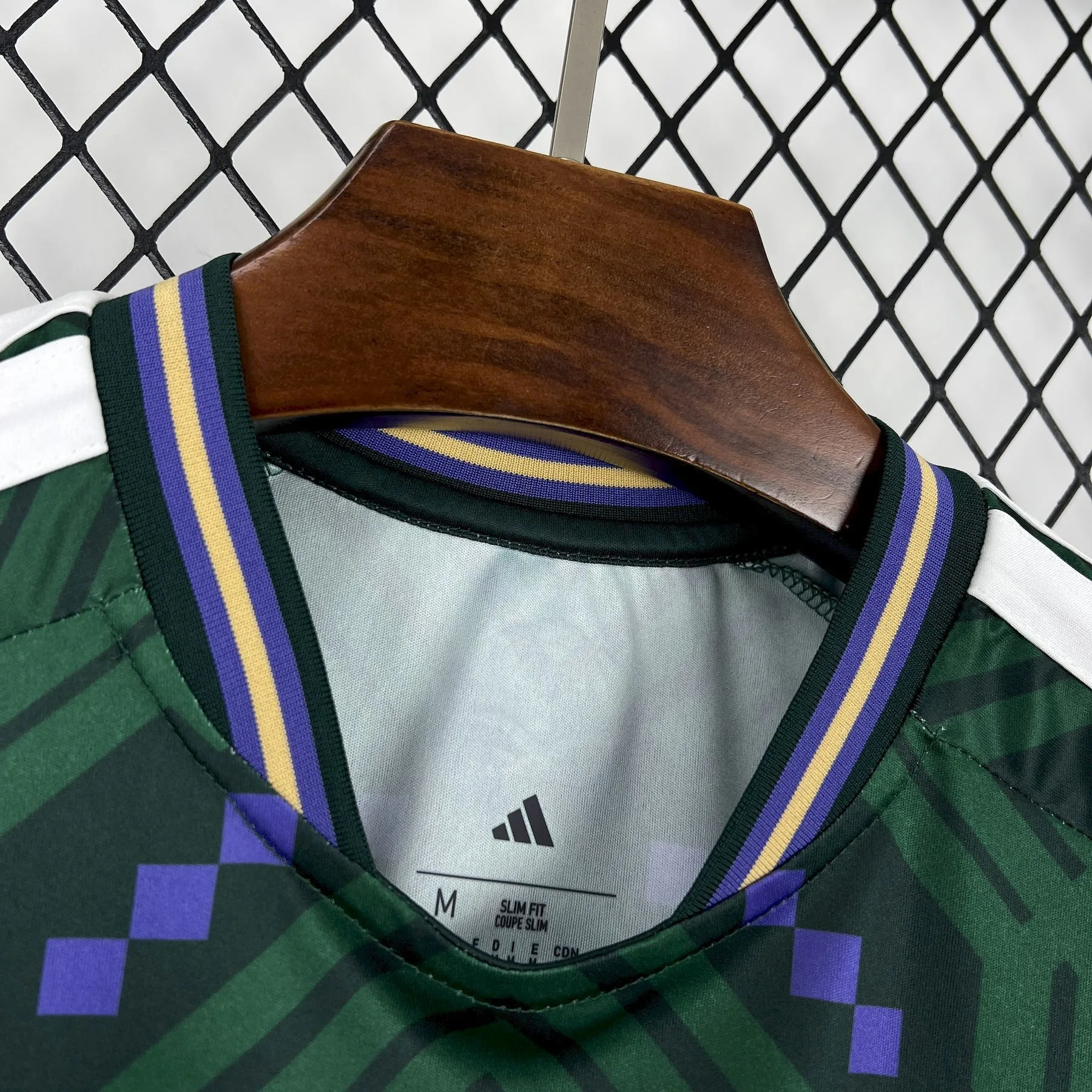 Detalle del cuello redondo con franjas amarillas y violetas de la camiseta de Arabia Saudita para el Mundial 2026.