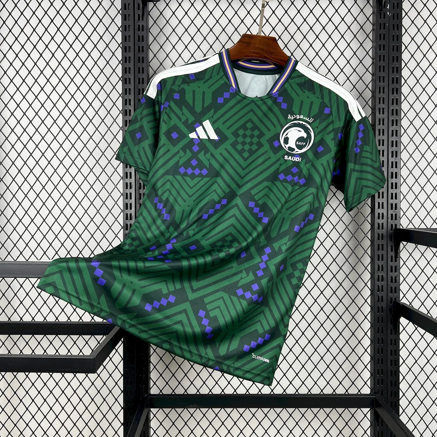 Camiseta de la selección de Arabia Saudita para el Mundial 2026 en color verde con patrón geométrico, tres franjas blancas en hombros y escudo de la SAFF.