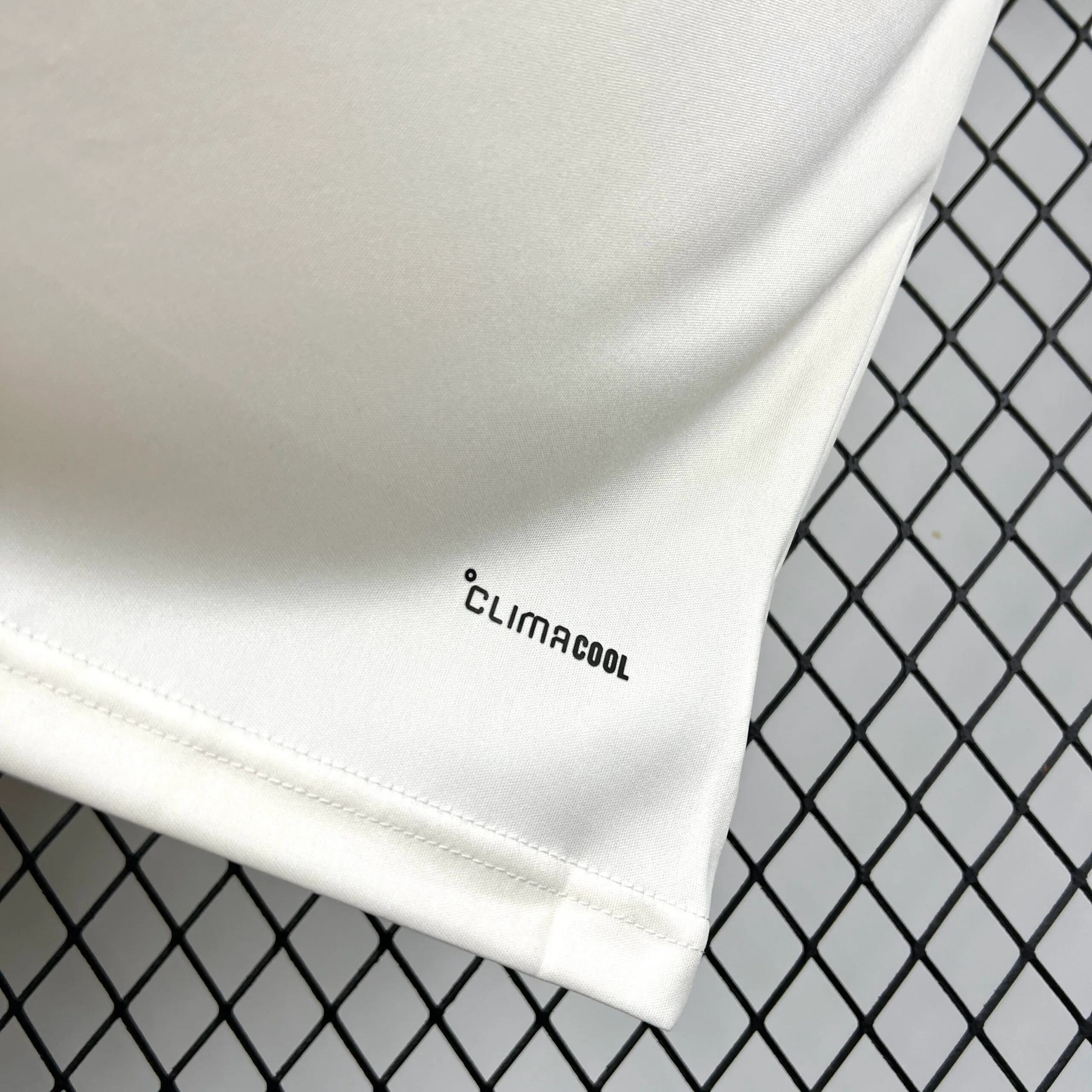 Primer plano del acabado inferior de la camiseta de Argelia mostrando el tejido técnico.
