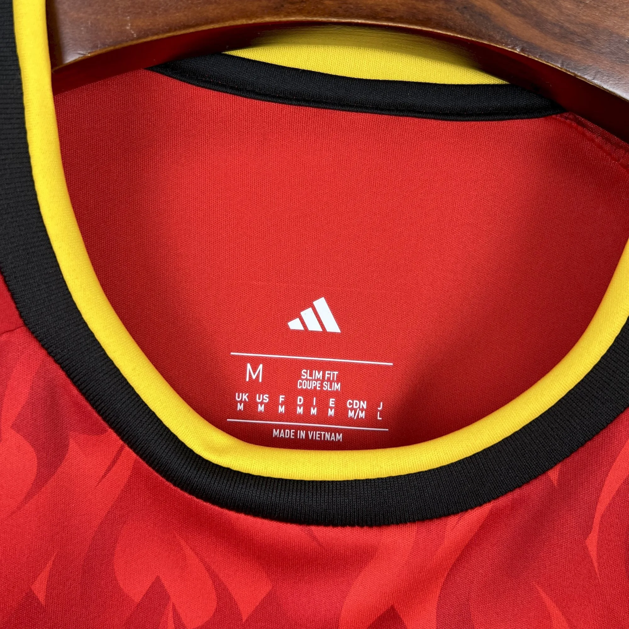 Detalle del cuello redondo en colores negro y amarillo de la camiseta de la selección de Bélgica.