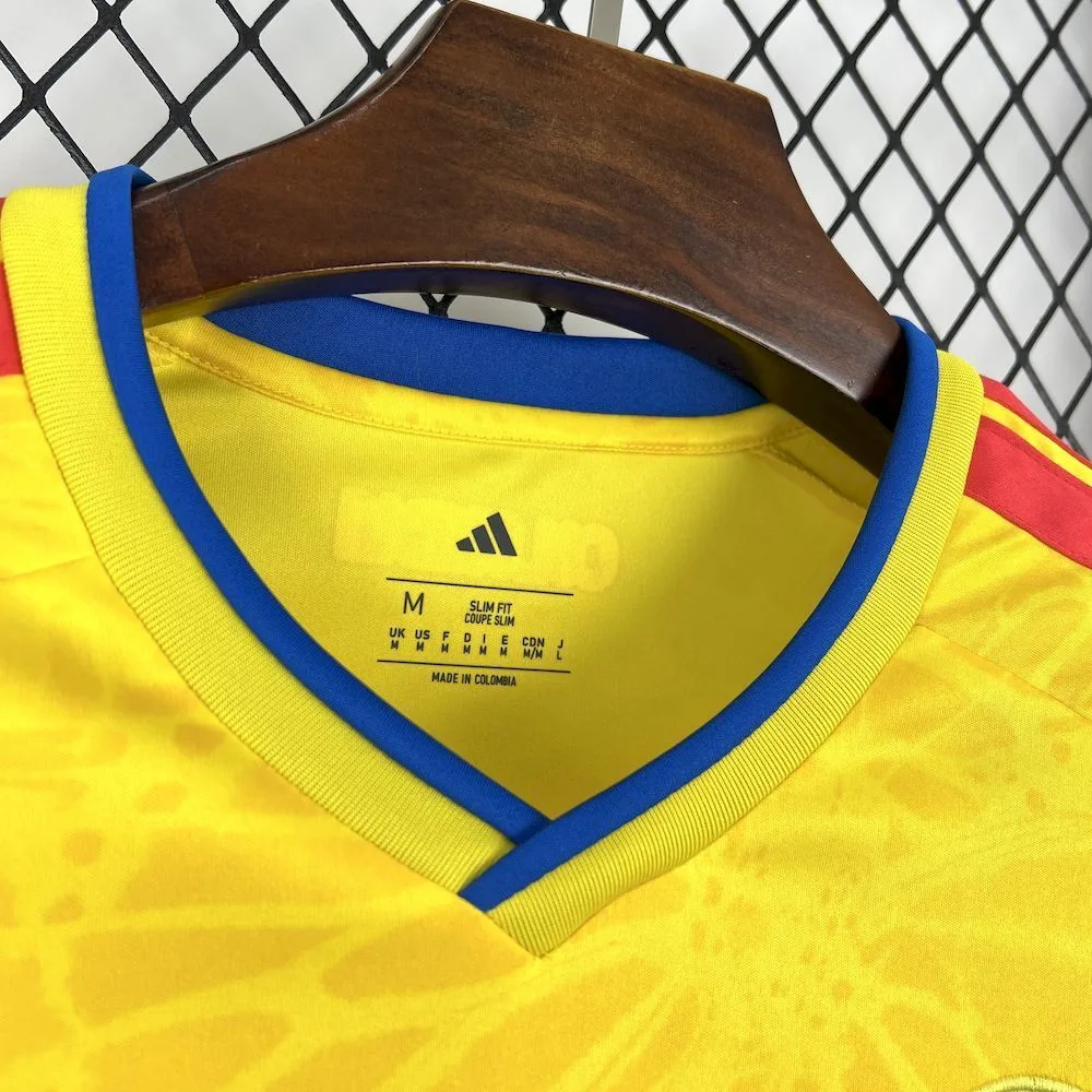 Detalle del cuello en V azul de la camiseta de Colombia con etiquetas internas de talla M y corte "Slim Fit".