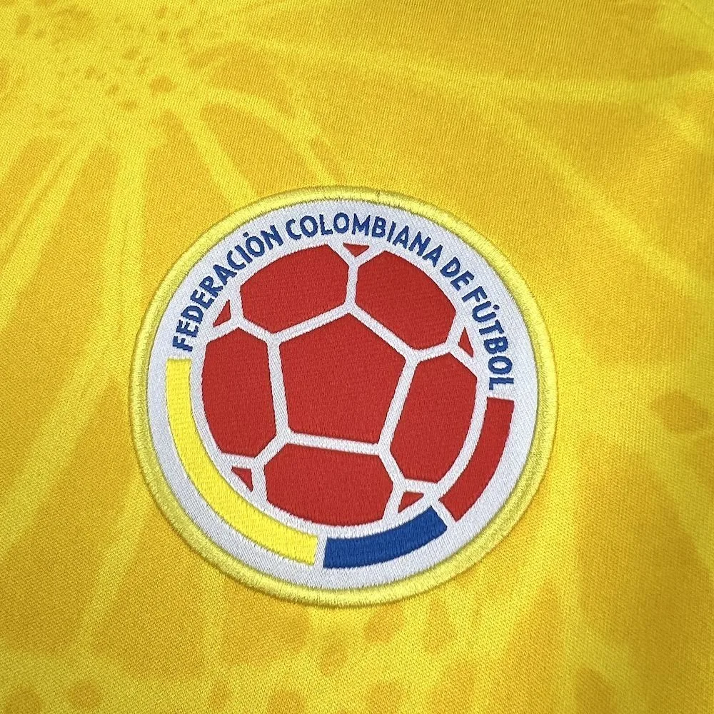 Primer plano del escudo de la Federación Colombiana de Fútbol bordado en el pecho de la camiseta oficial.