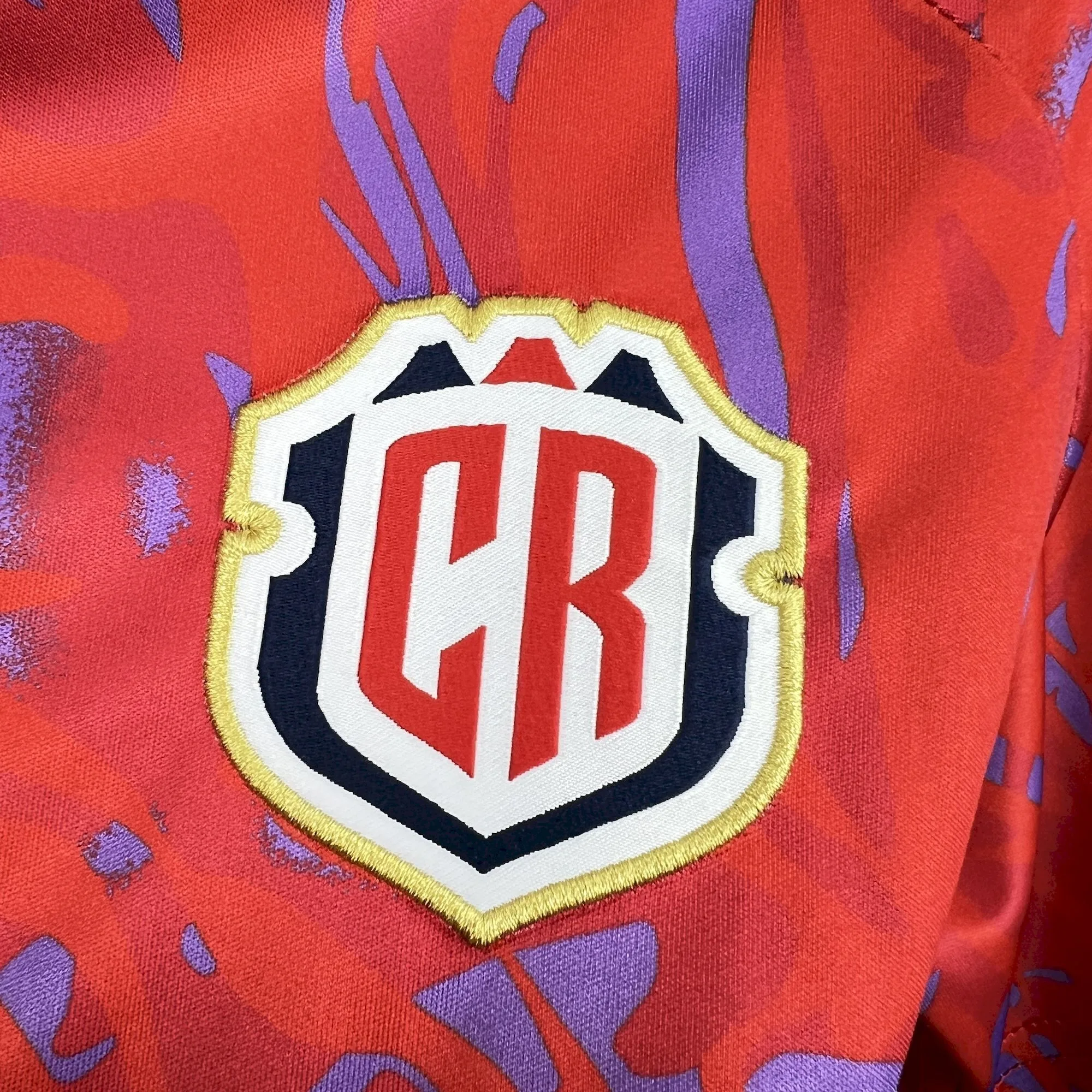 Primer plano del nuevo escudo de la Federación Costarricense de Fútbol (FCRF) bordado en la camiseta oficial para el Mundial 2026.