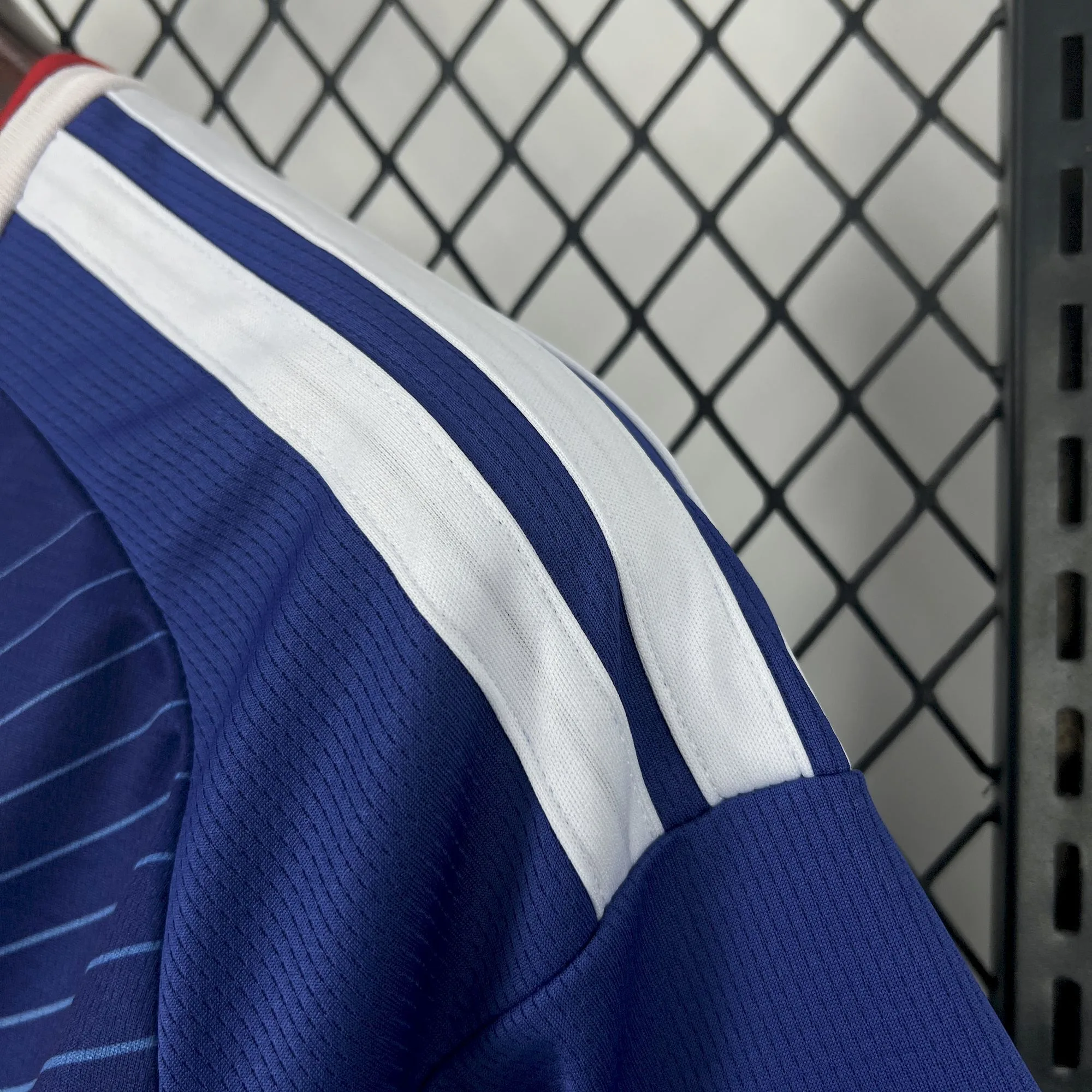 Vista de las franjas blancas sobre el hombro azul de la camiseta de la selección japonesa.