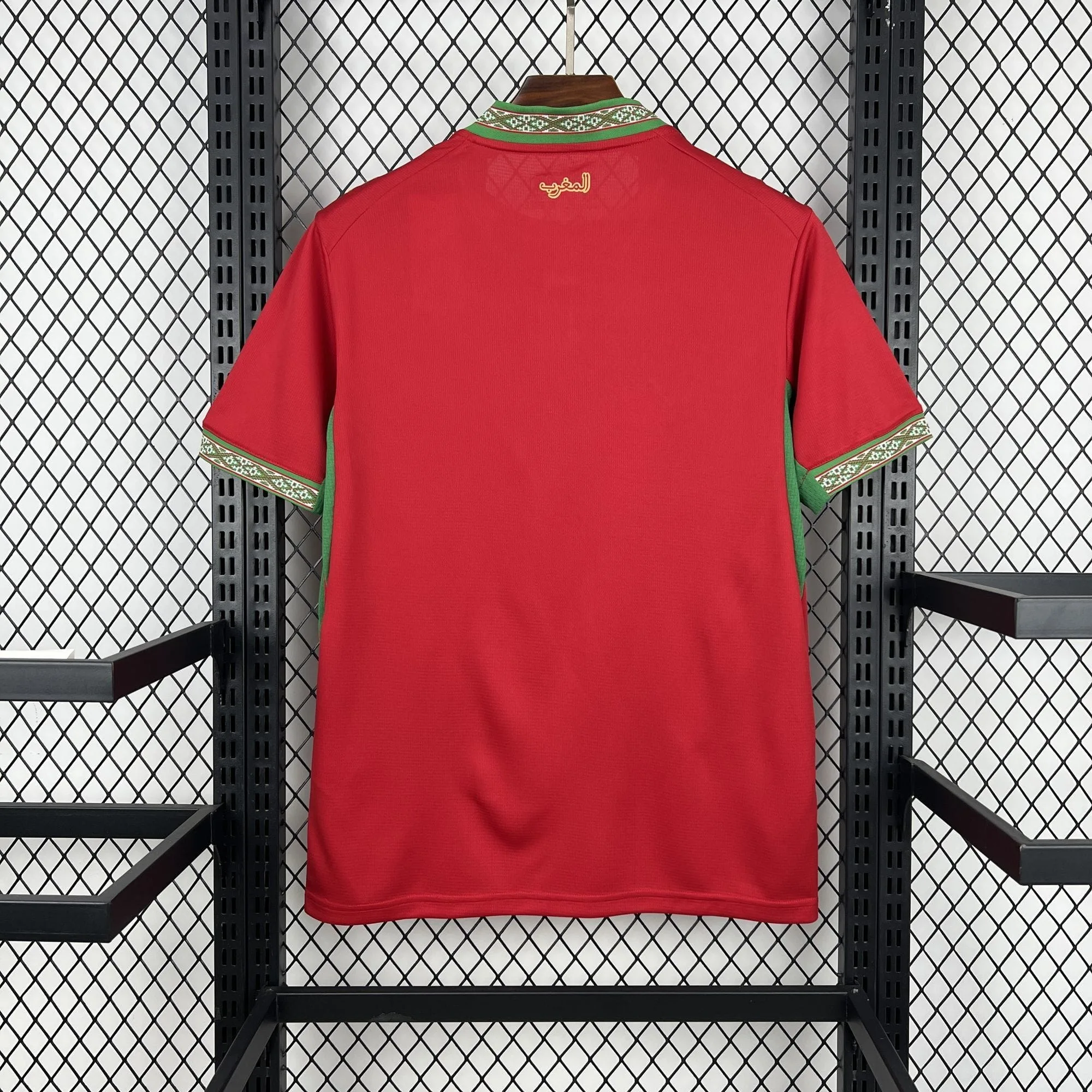 Espalda de la camiseta de Marruecos en color rojo liso con el cuello verde decorado y una inscripción bordada en dorado en la nuca.