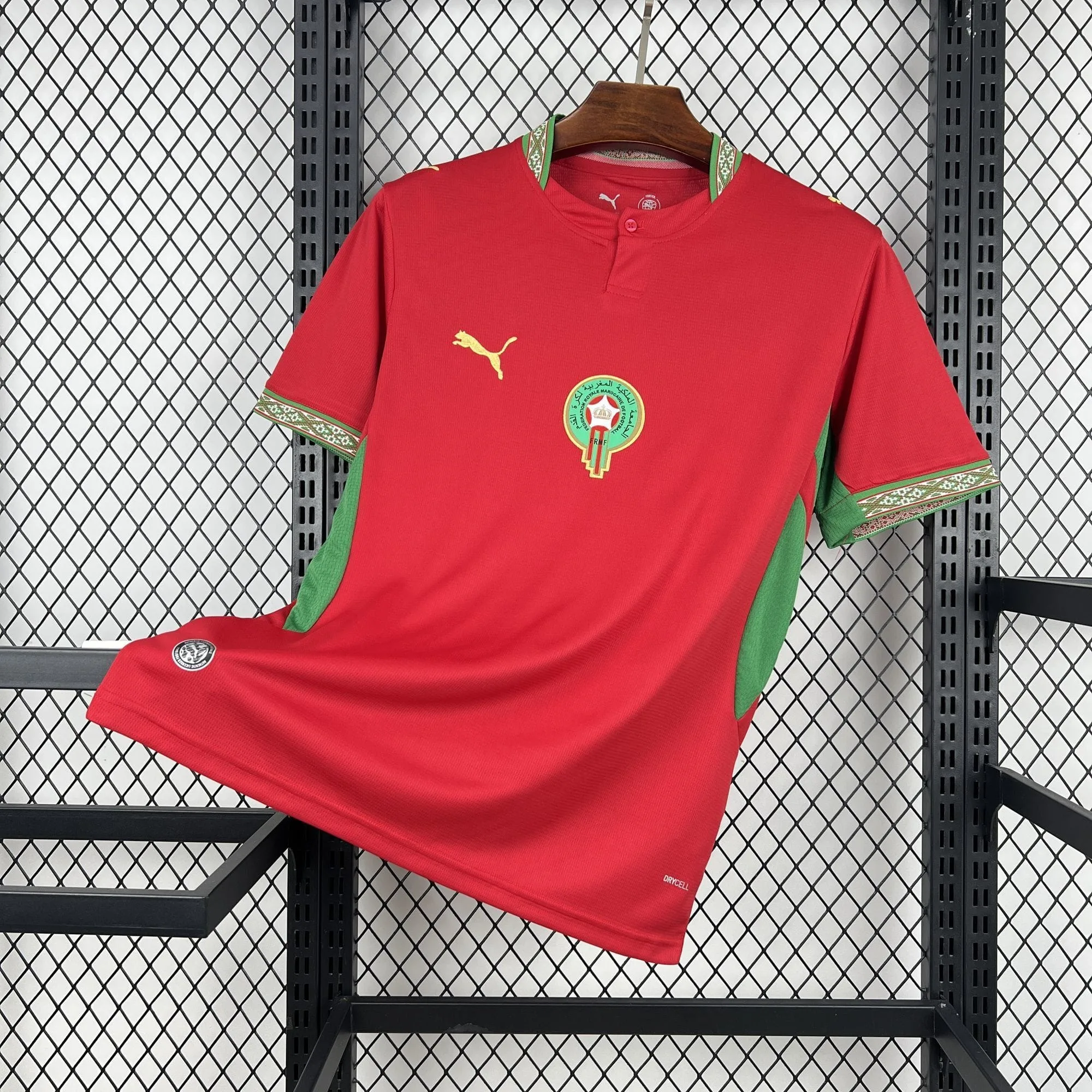Camiseta de la selección de Marruecos en color rojo con paneles verdes laterales y ribetes con motivos tradicionales en el cuello y las mangas.