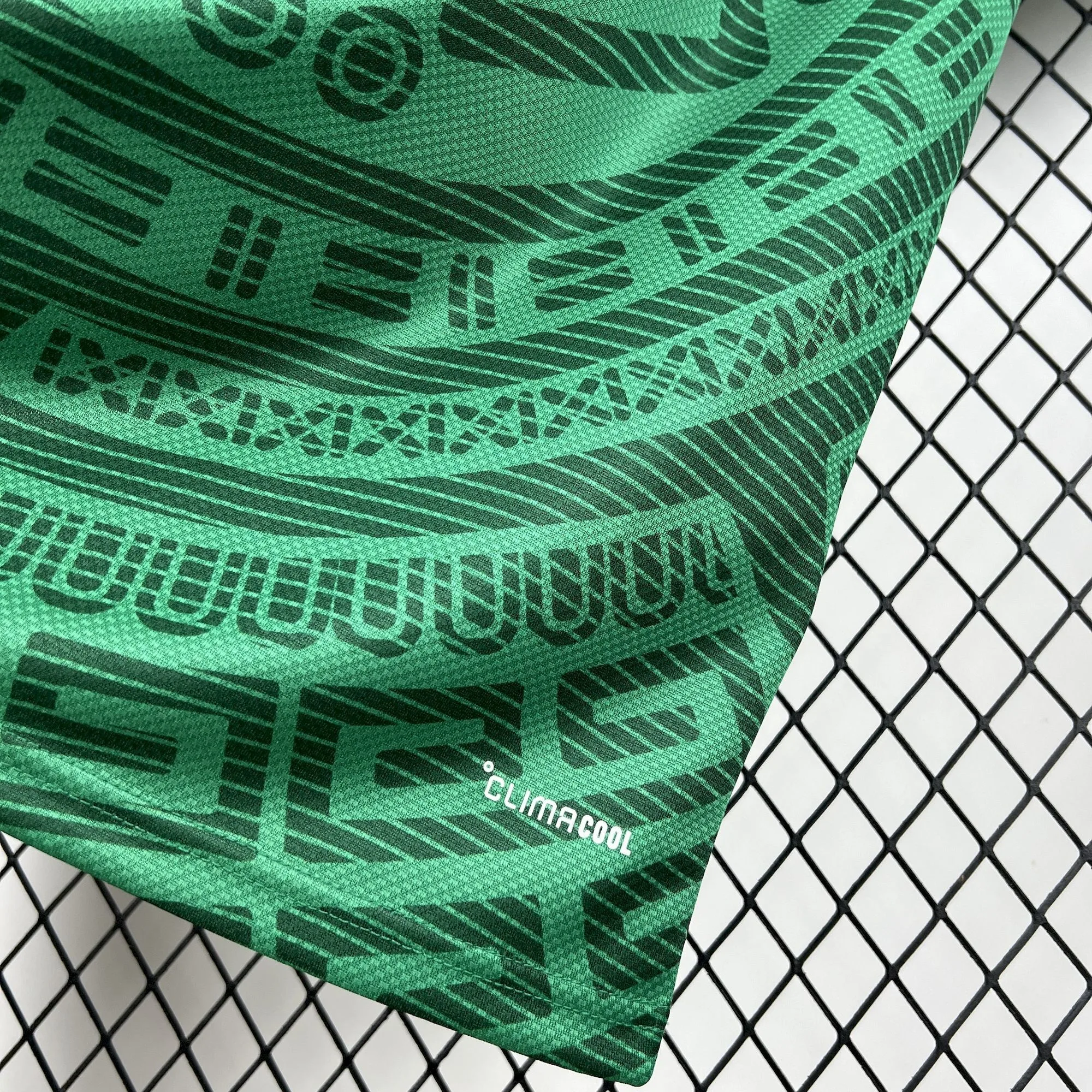 Sello de tecnología de transpiración en color blanco sobre el tejido técnico verde con patrones aztecas de la camiseta de México 2026.