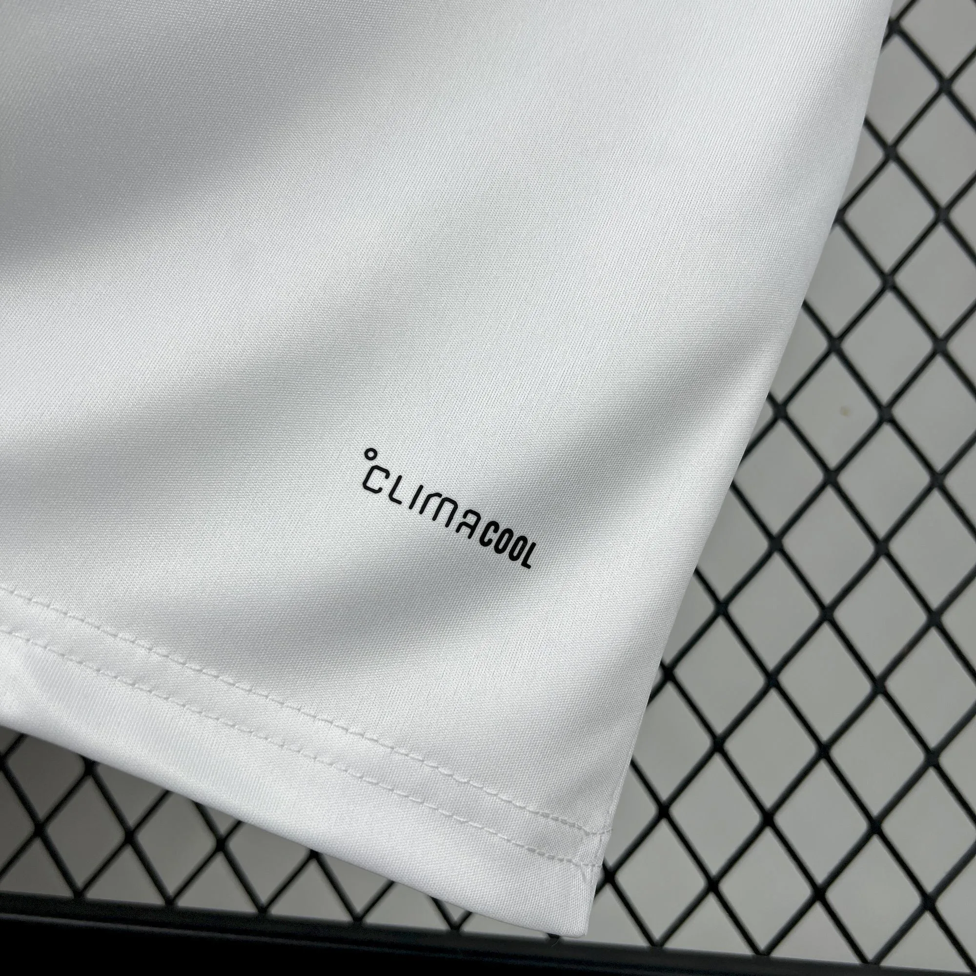 Sello de tecnología textil en color negro sobre el tejido técnico blanco de la equipación de Perú 2026.