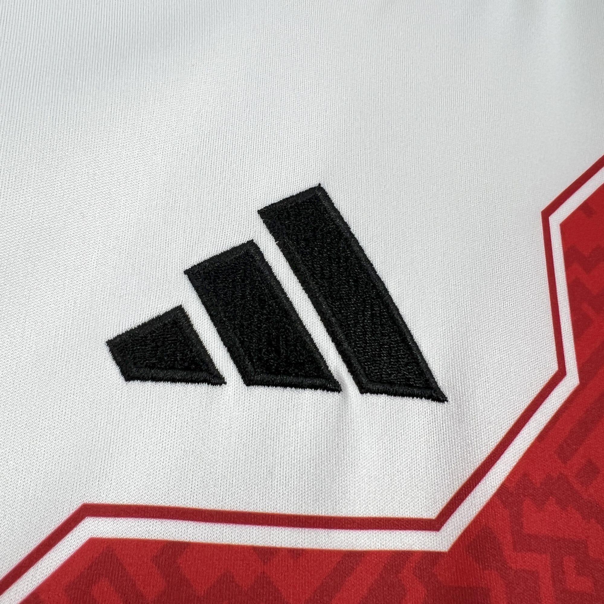 Detalle del logotipo bordado en color negro sobre el tejido blanco del pecho de la camiseta de Perú para el Mundial 2026.