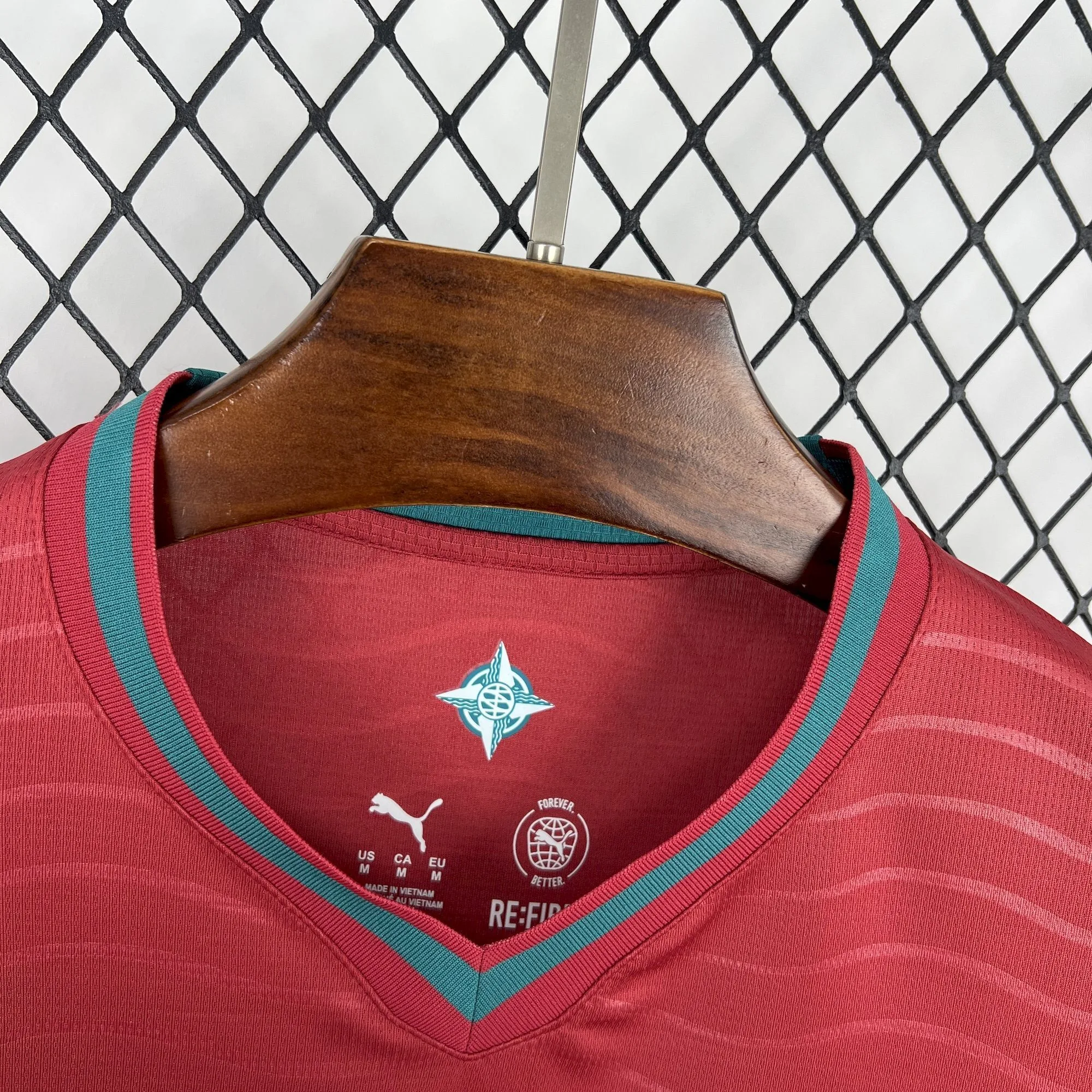 Detalle del cuello en forma de "V" con ribete verde de la camiseta de la selección portuguesa.