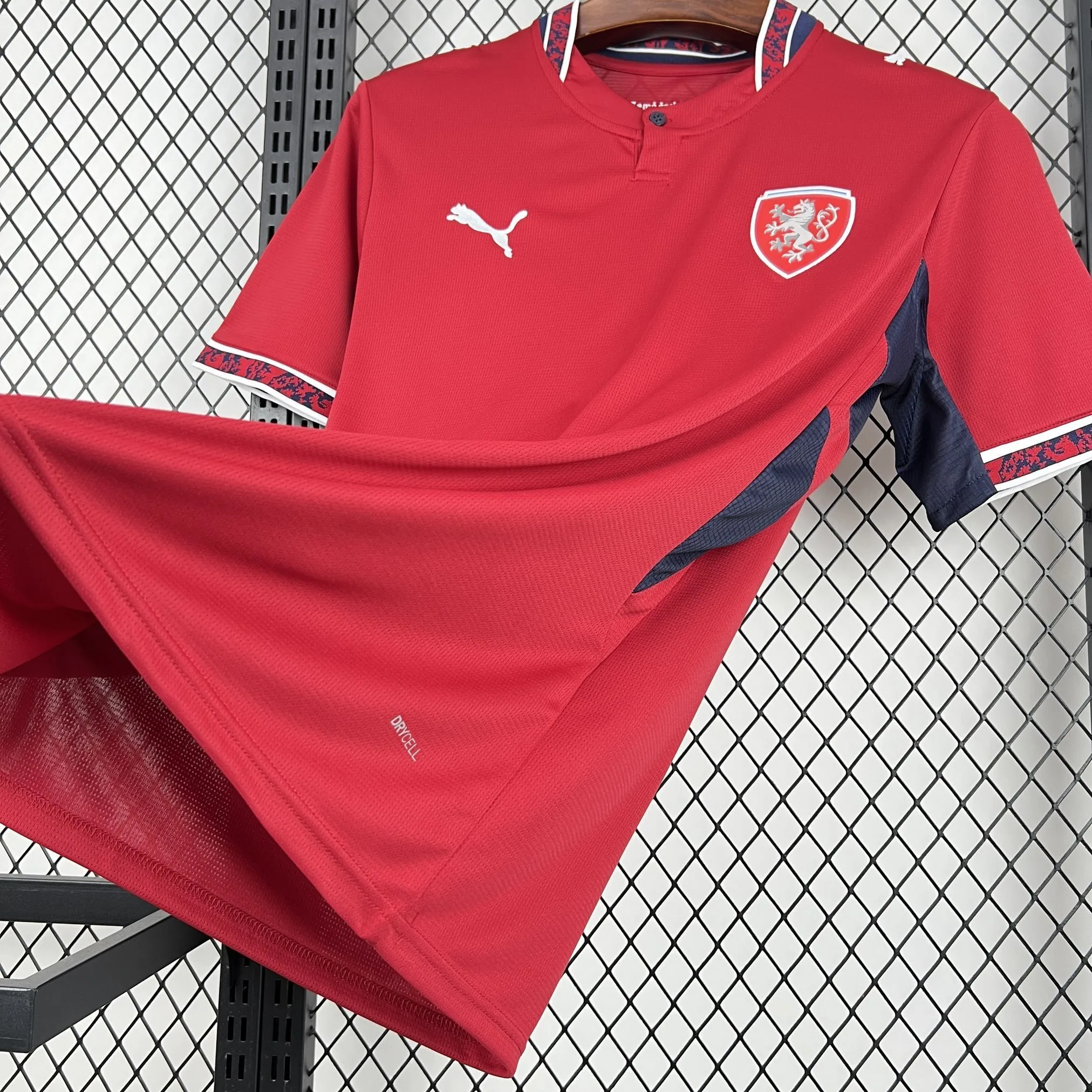 Perspectiva lateral de la camiseta de la República Checa 2026, resaltando la tecnología DryCell, el panel lateral azul marino y la caída del tejido técnico.