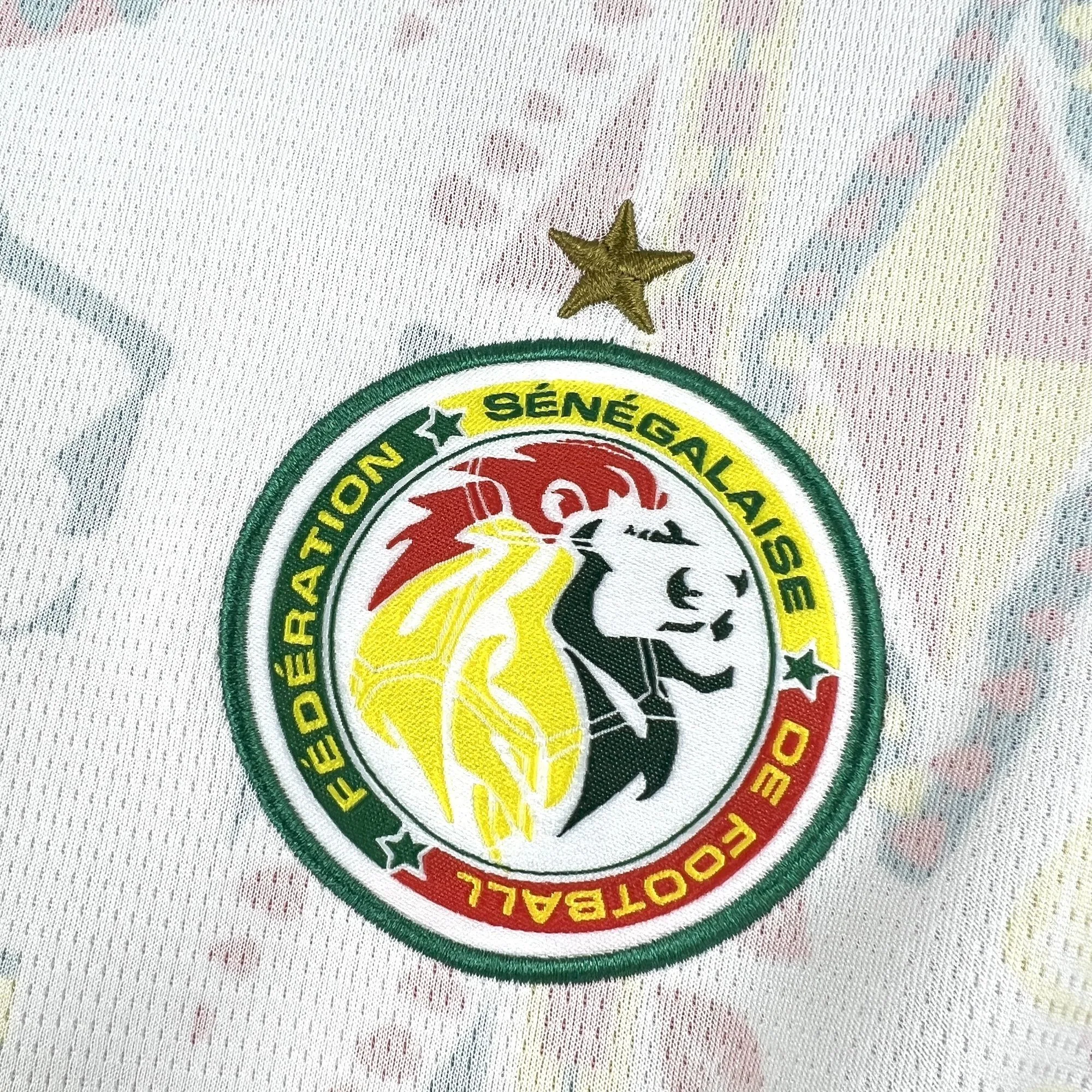 Detalle del escudo de la Federación Senegalesa de Fútbol bordado con una estrella dorada.