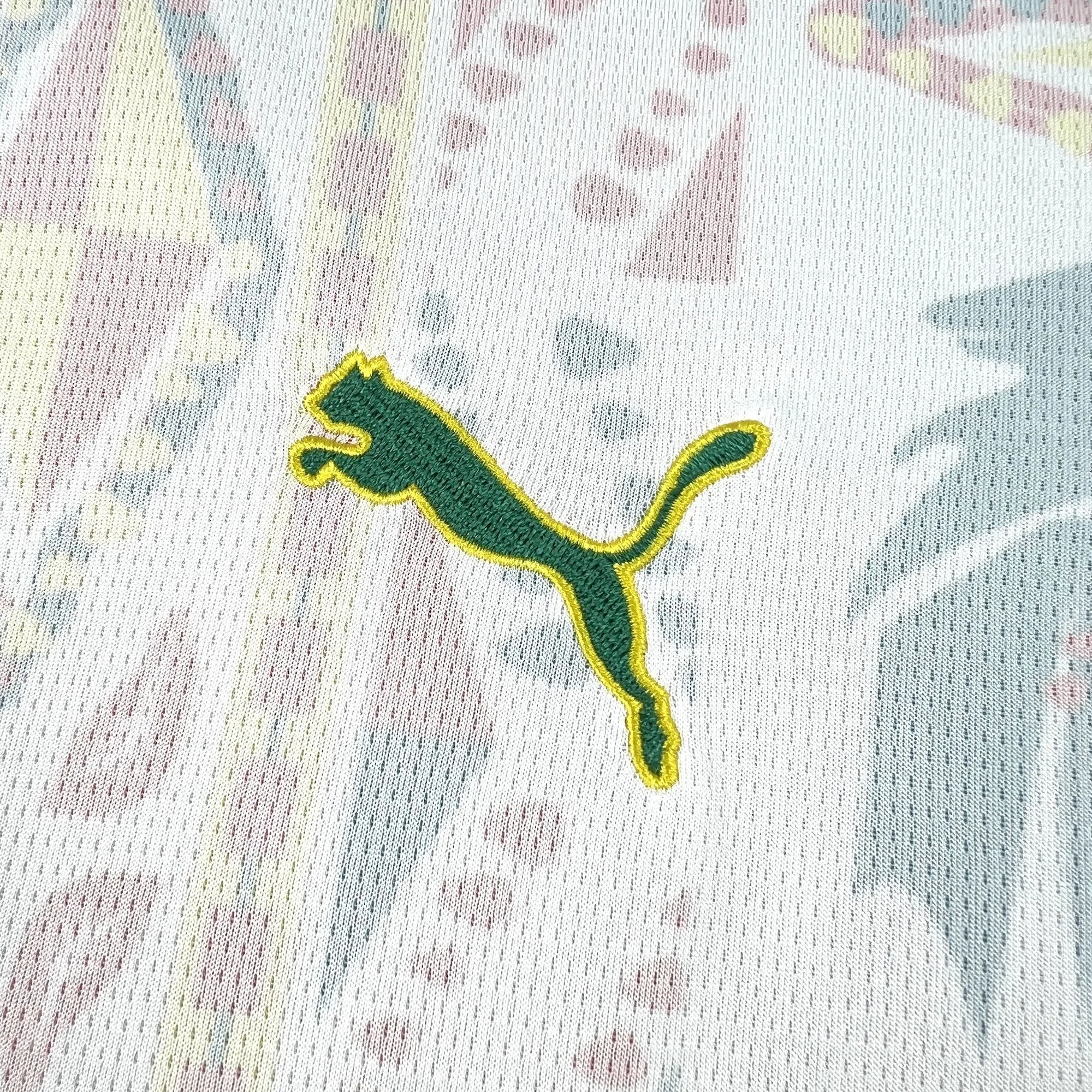 Detalle de logotipo decorativo bordado en color verde sobre el tejido blanco de Senegal.