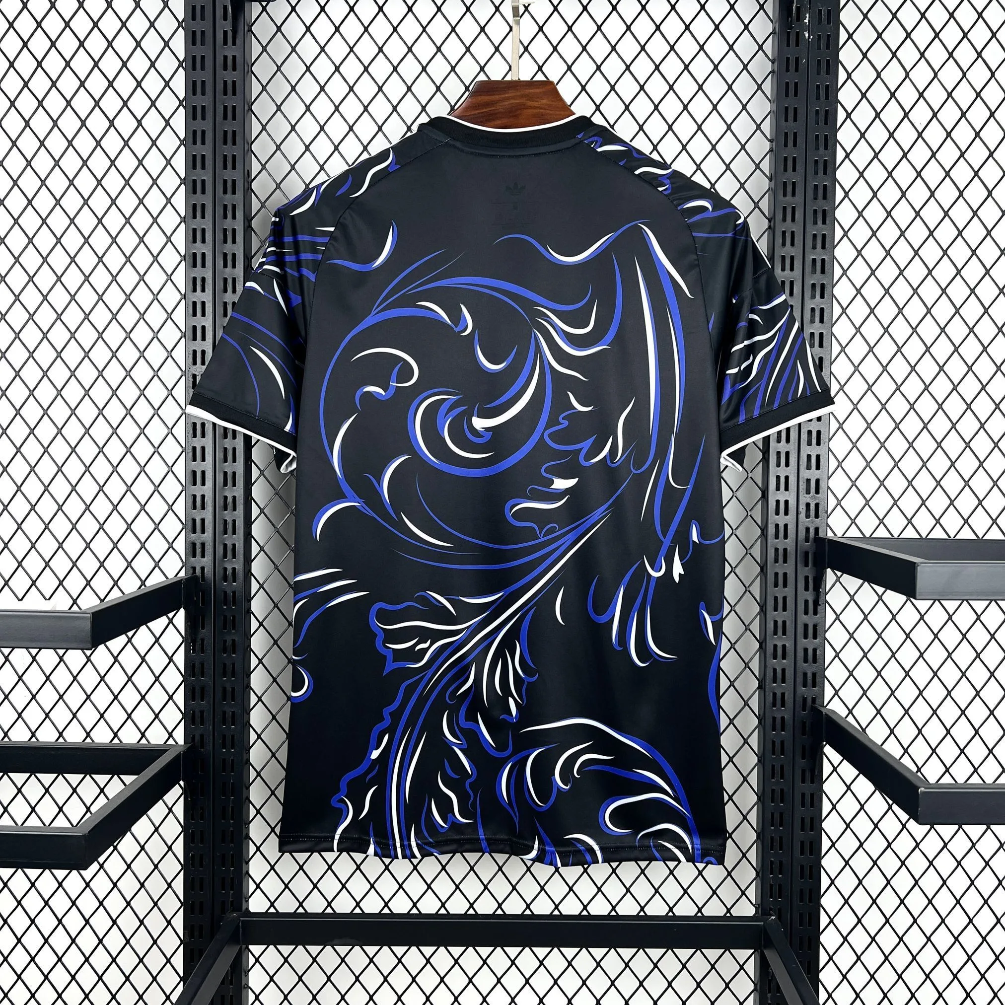 Vista posterior de la camiseta de Argentina visitante para el Mundial 2026 en color azul oscuro con patrón tricolor en el hombro.