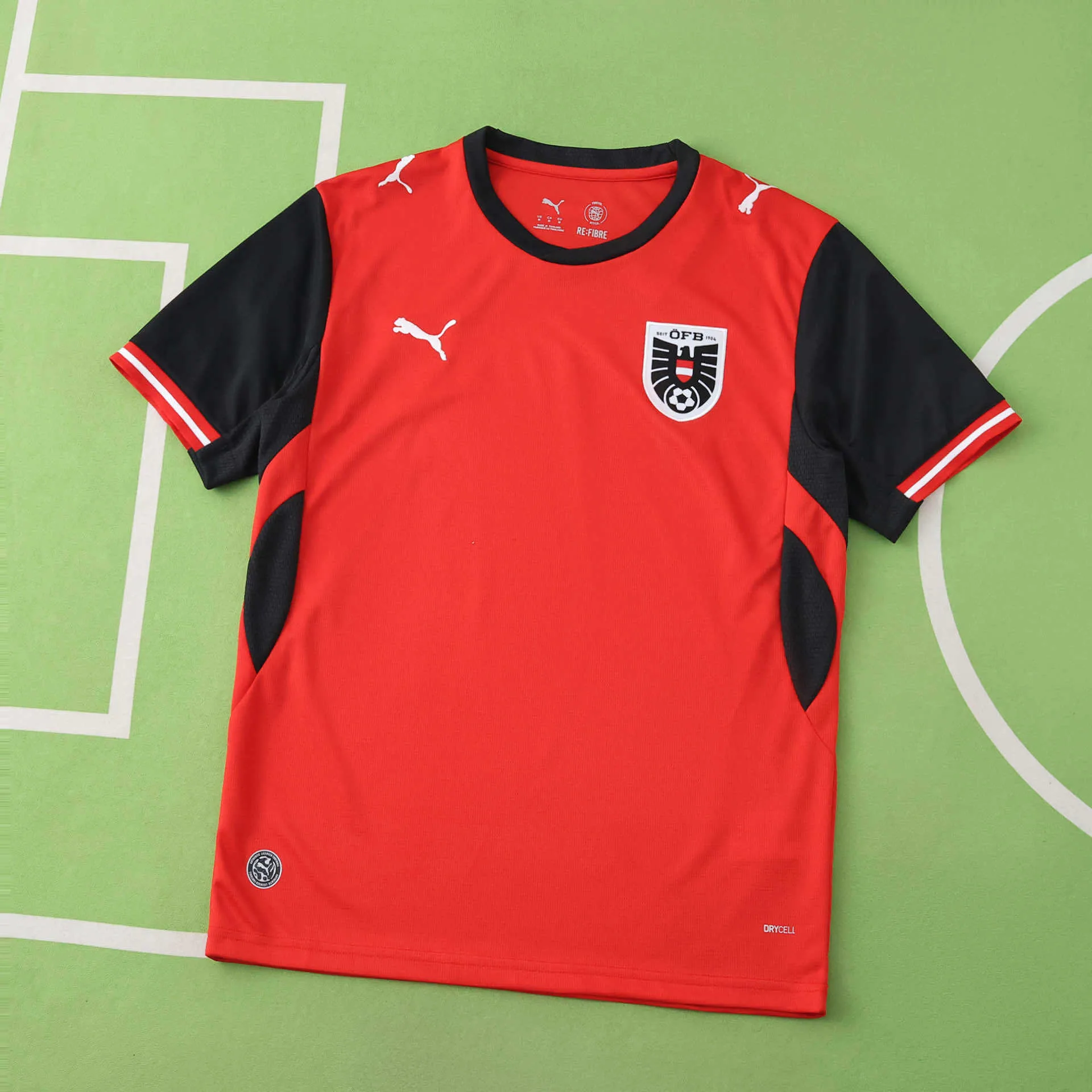 Vista frontal de la camiseta de Austria para el Mundial 2026 en color rojo con mangas negras.