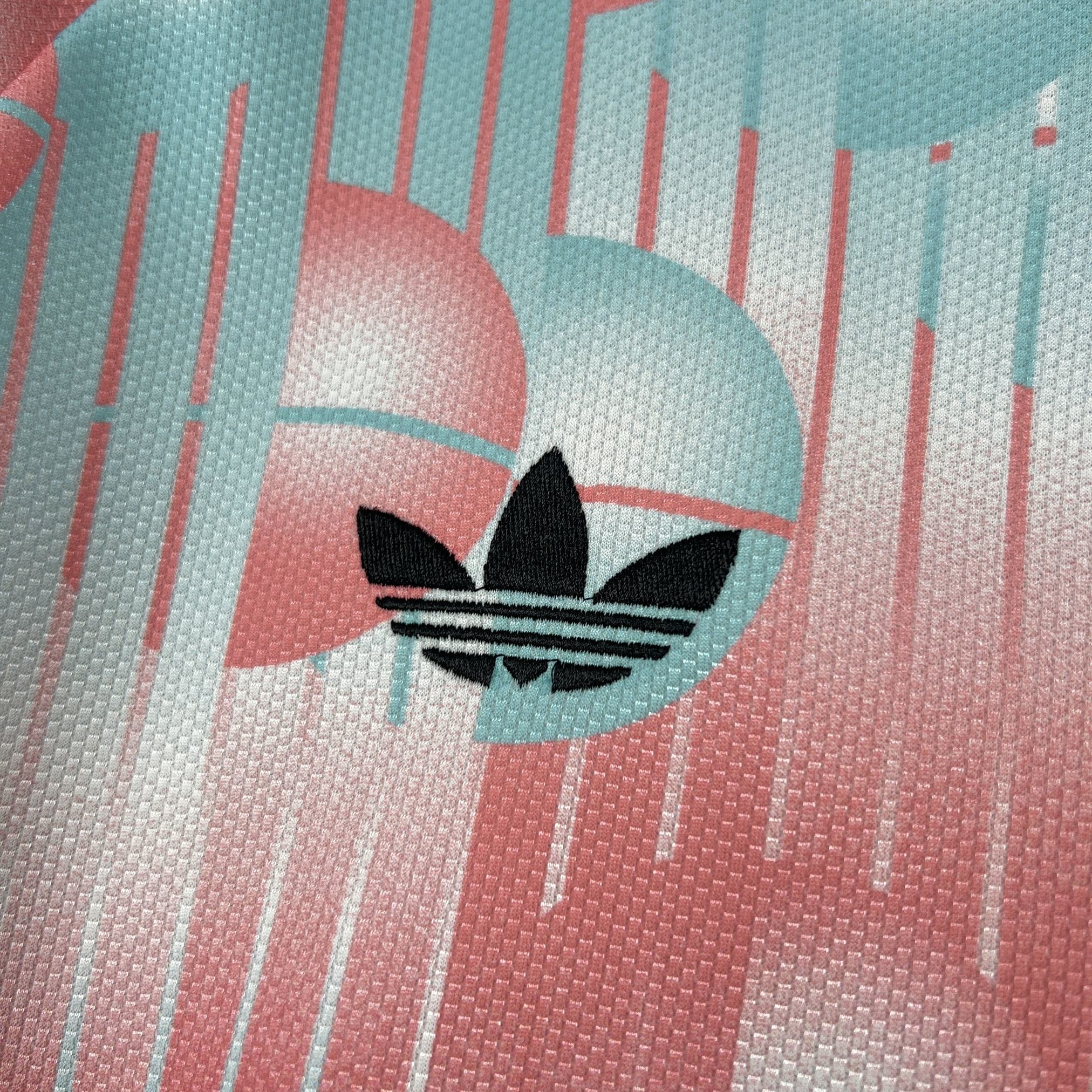 Detalle de logotipo decorativo bordado en color blanco sobre el patrón de rombos de la camiseta visitante.