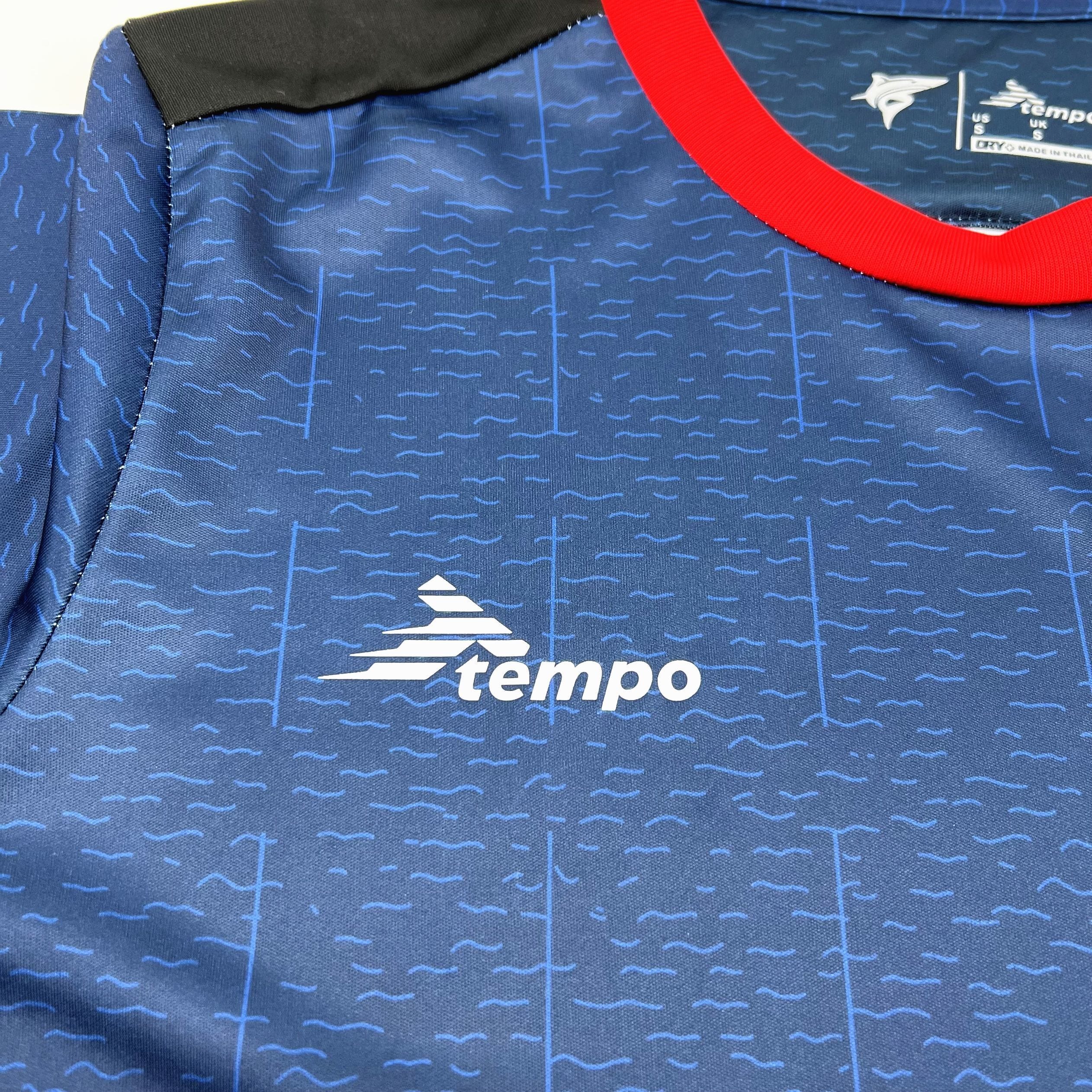 Detalle del logotipo decorativo en color blanco sobre el tejido azul con patrón de ondas de agua.