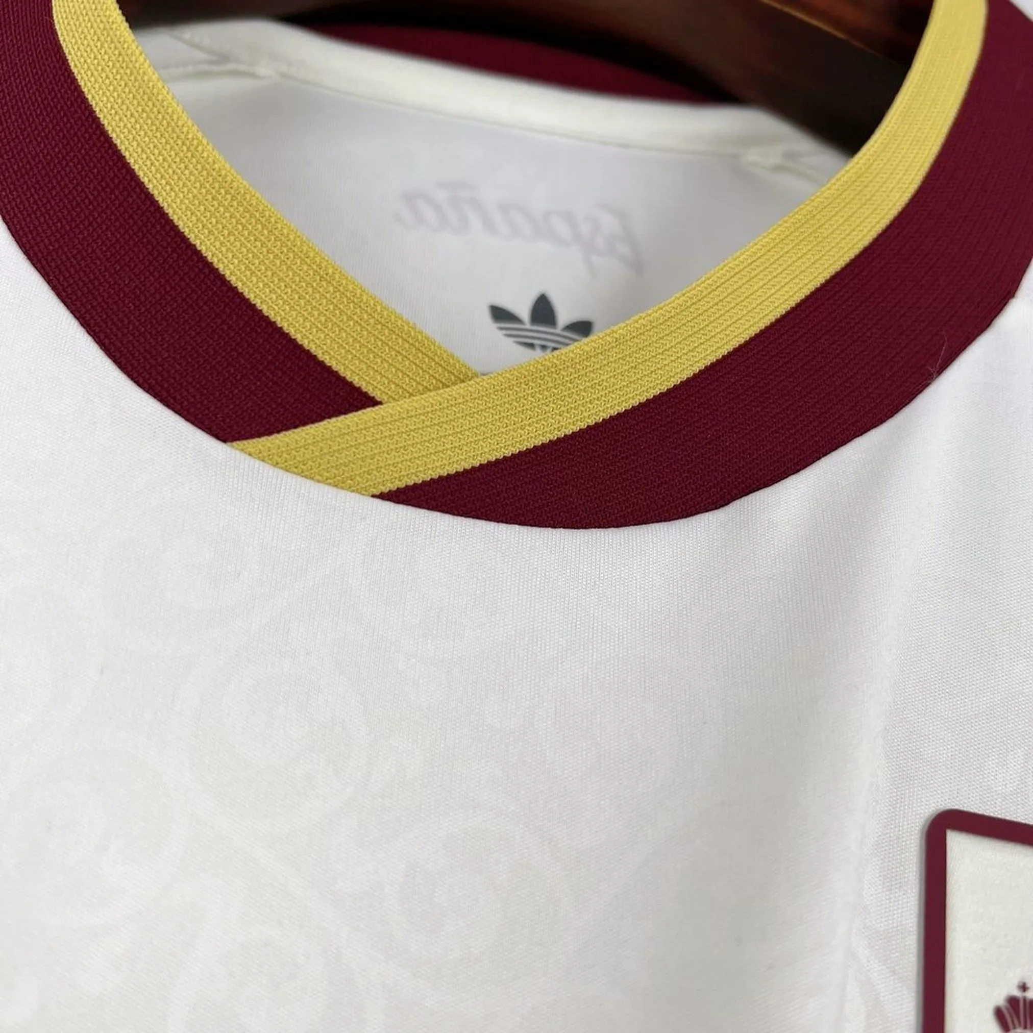 Detalle frontal del cuello redondo en color azul marino con vivos amarillos y rojos de la segunda equipación de España.
