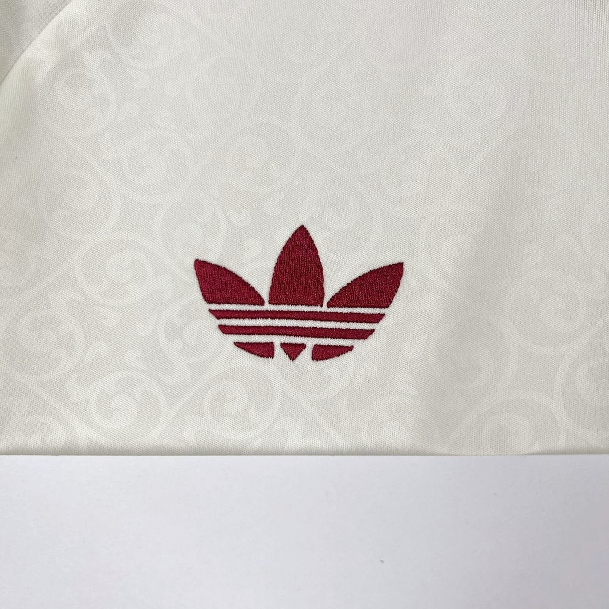 Detalle de elemento decorativo bordado en color amarillo sobre el tejido azul de la camiseta de la selección española.