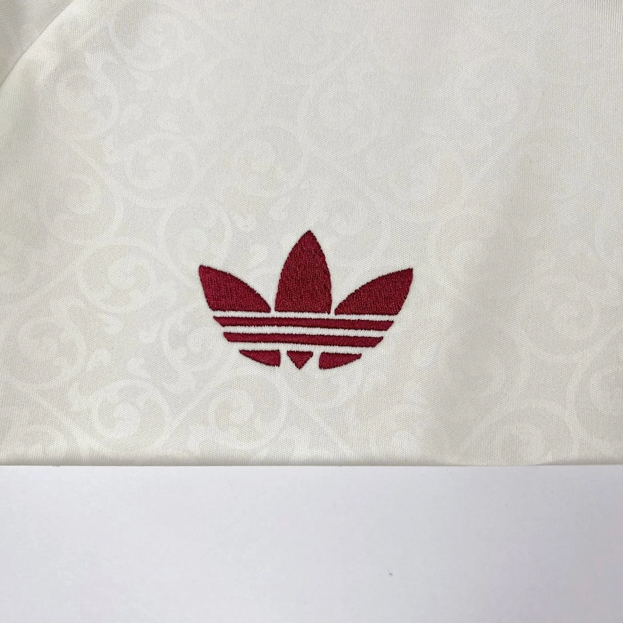 Detalle de elemento decorativo bordado en color amarillo sobre el tejido azul de la camiseta de la selección española.