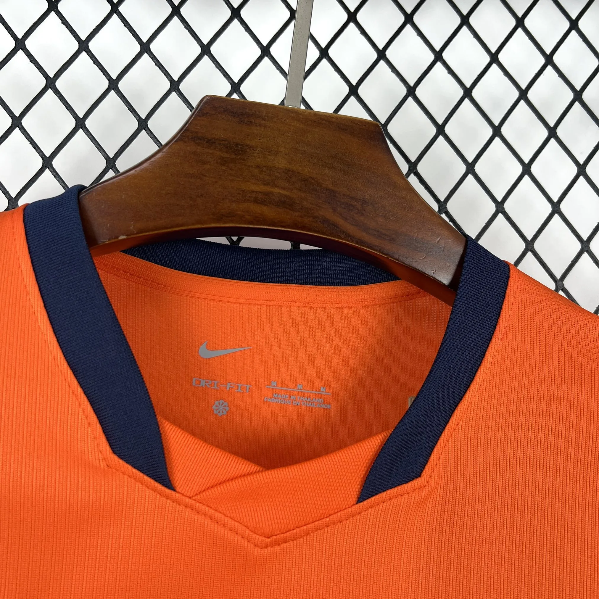 Detalle frontal del cuello redondo de la camiseta de los Países Bajos con ribete bicolor negro y naranja.