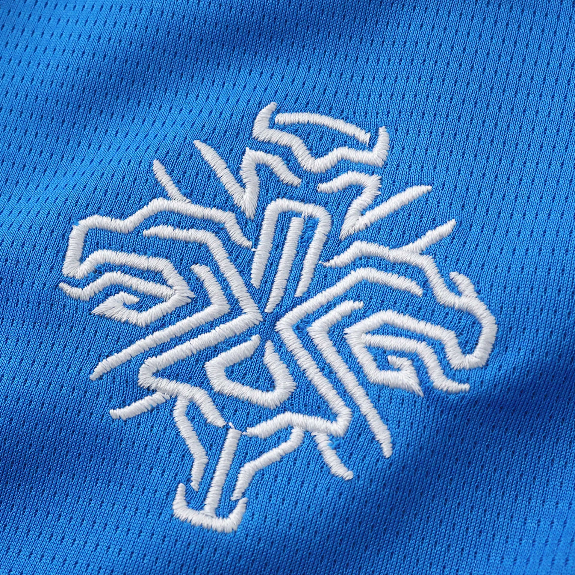 Detalle del escudo artístico bordado de la selección de Islandia en color blanco sobre azul.