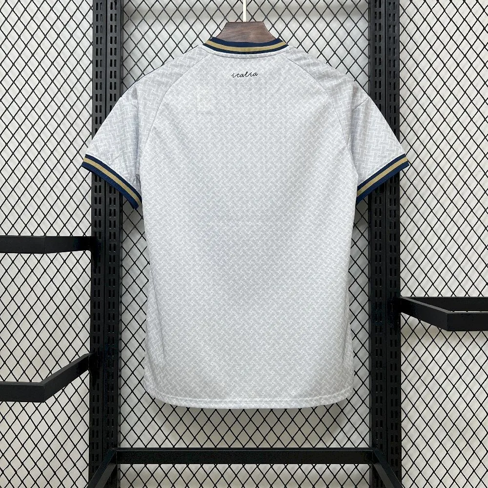 Vista posterior de la camiseta de Italia visitante para el Mundial 2026 en color blanco con detalles tricolores en los hombros.