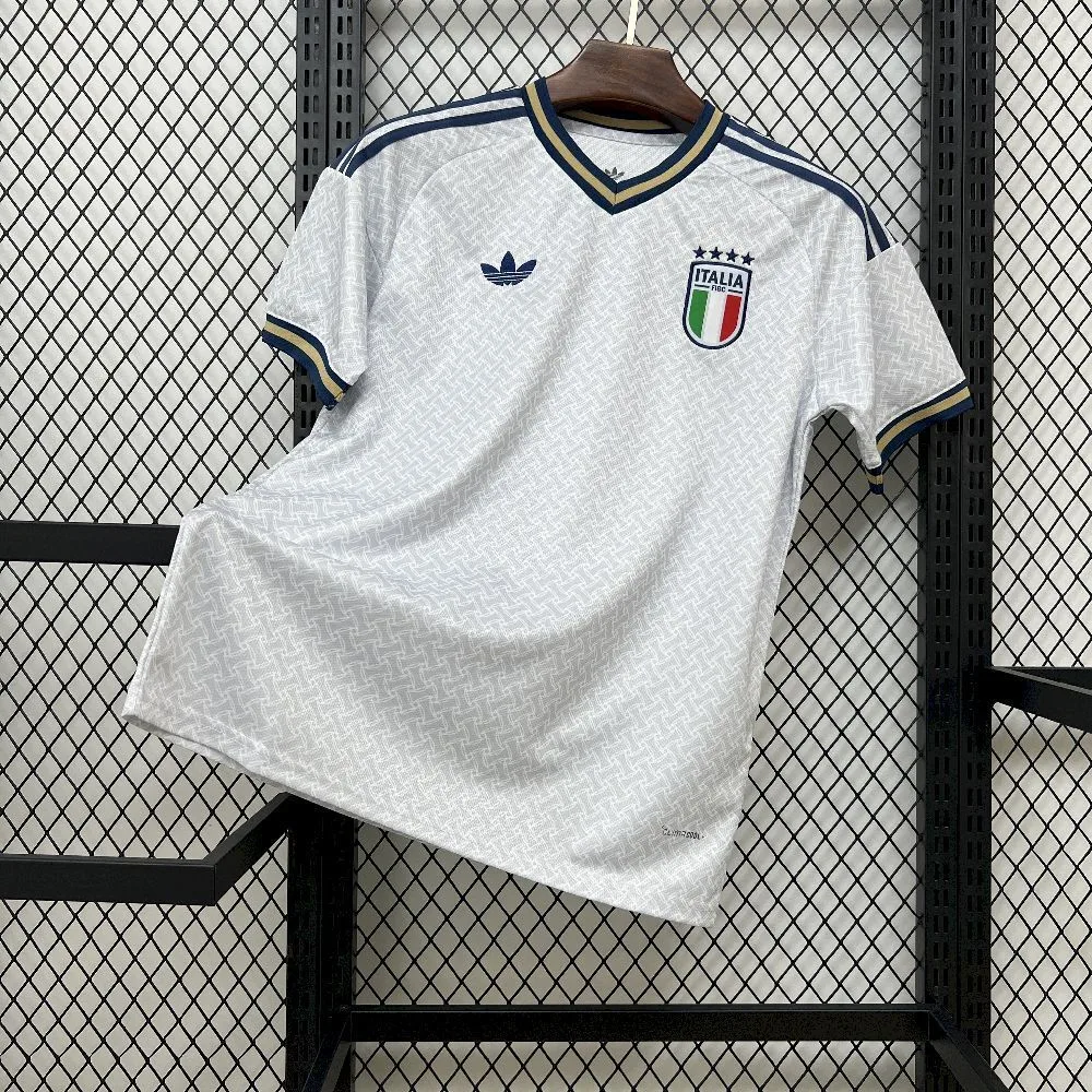 Imagen frontal completa de la camiseta visitante de Italia 2026, diseño blanco con vivos tricolores y detalles azules.