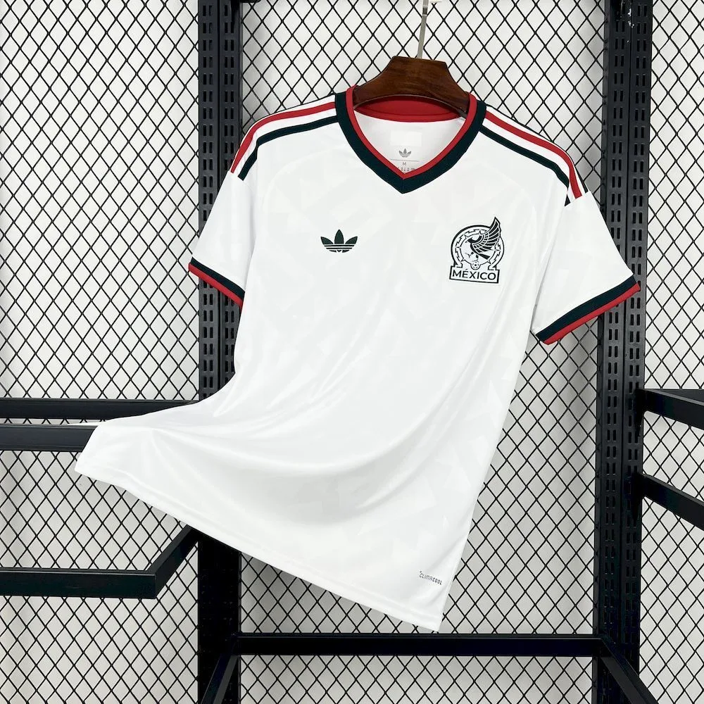 Vista frontal completa de la camiseta visitante de México para el Mundial 2026, en color blanco con sutiles patrones gráficos de inspiración cultural.