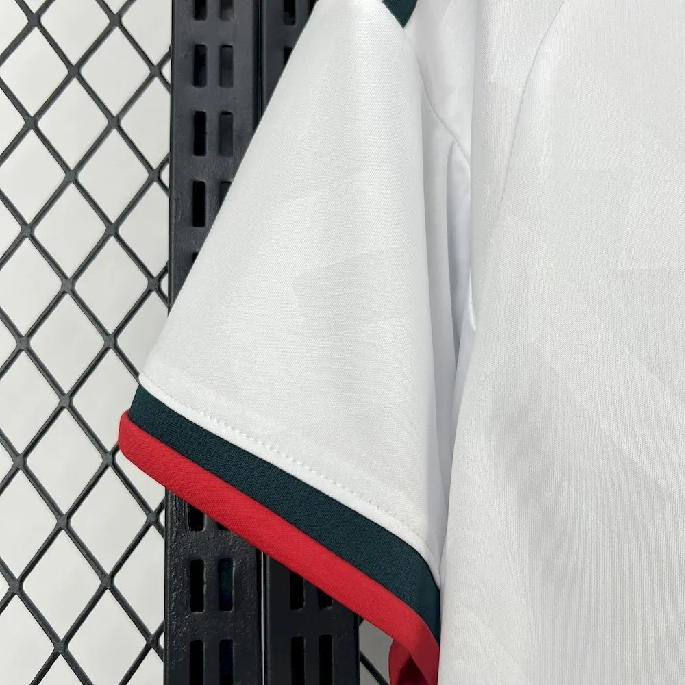 Detalle del hombro y manga de la equipación de México con franjas verdes sobre el tejido blanco texturizado.