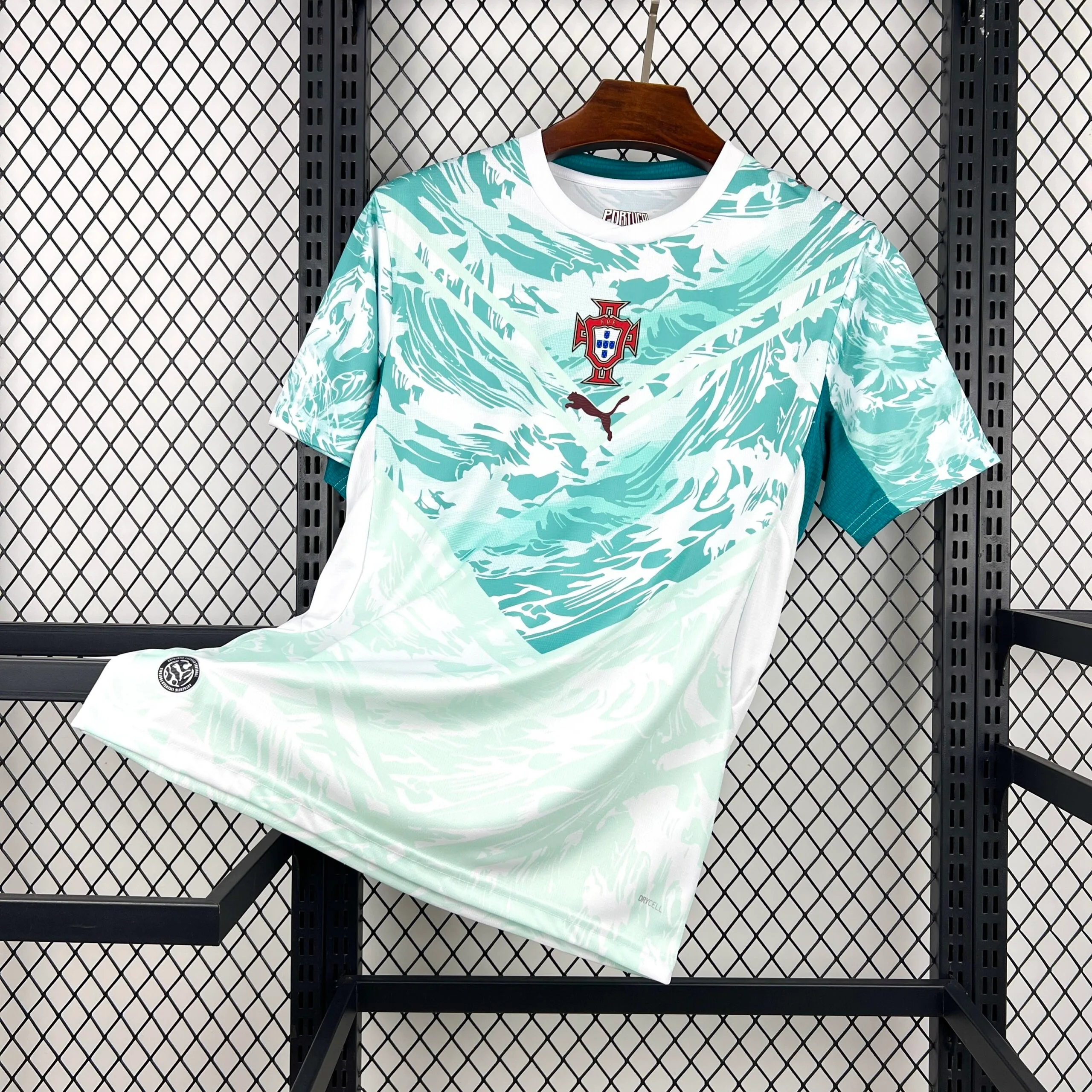 Imagen frontal completa de la camiseta de Portugal visitante para el Mundial 2026, color blanco con gráficos de azulejos azules.