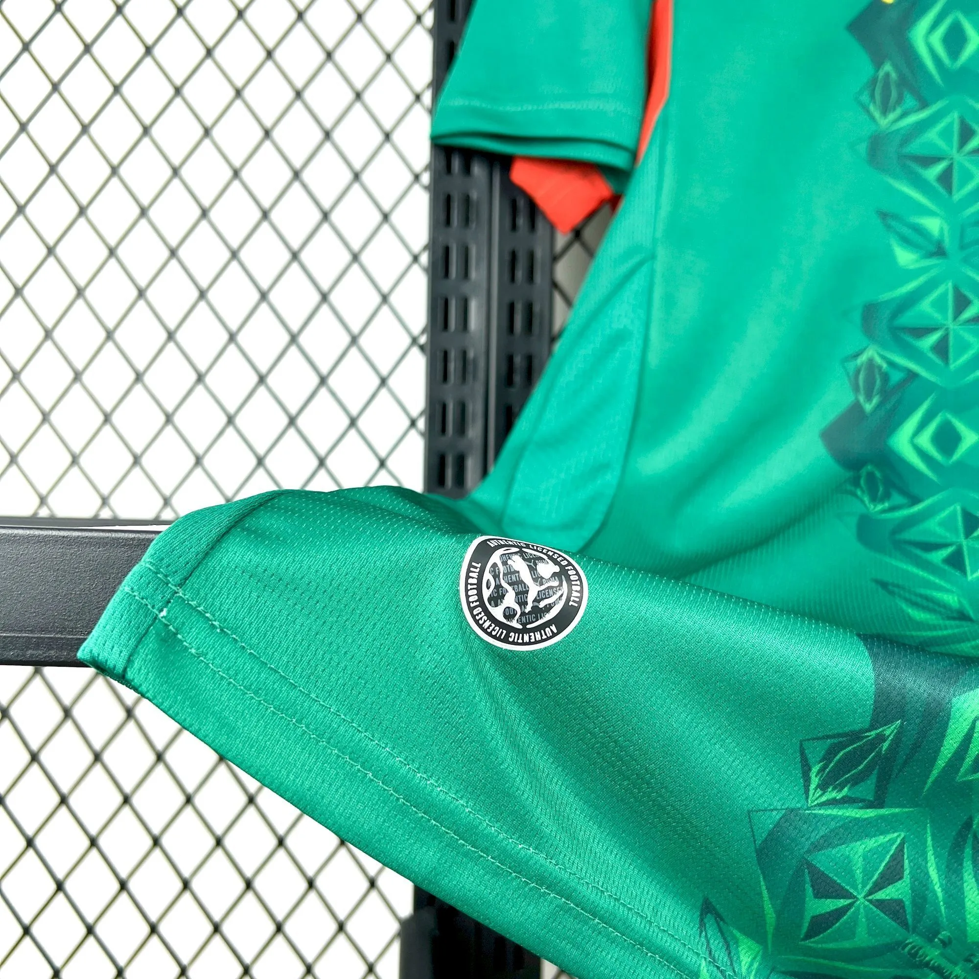 Primer plano del tejido técnico verde y detalle del acabado en la parte inferior de la segunda equipación senegalesa.
