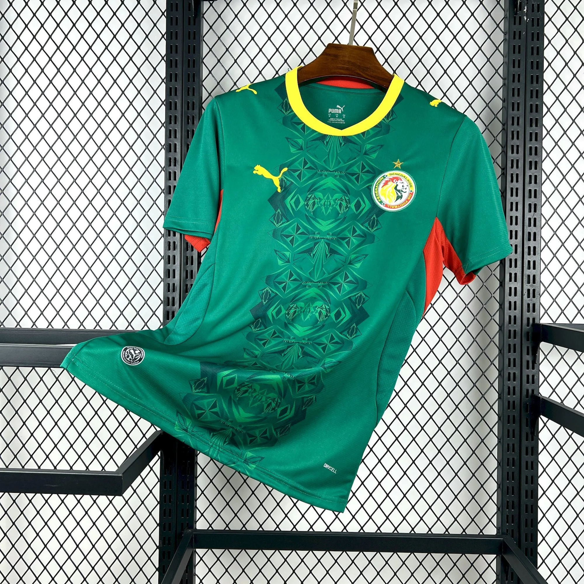 Imagen frontal completa de la camiseta de Senegal visitante 2026, destacando el color verde y el diseño artístico central.