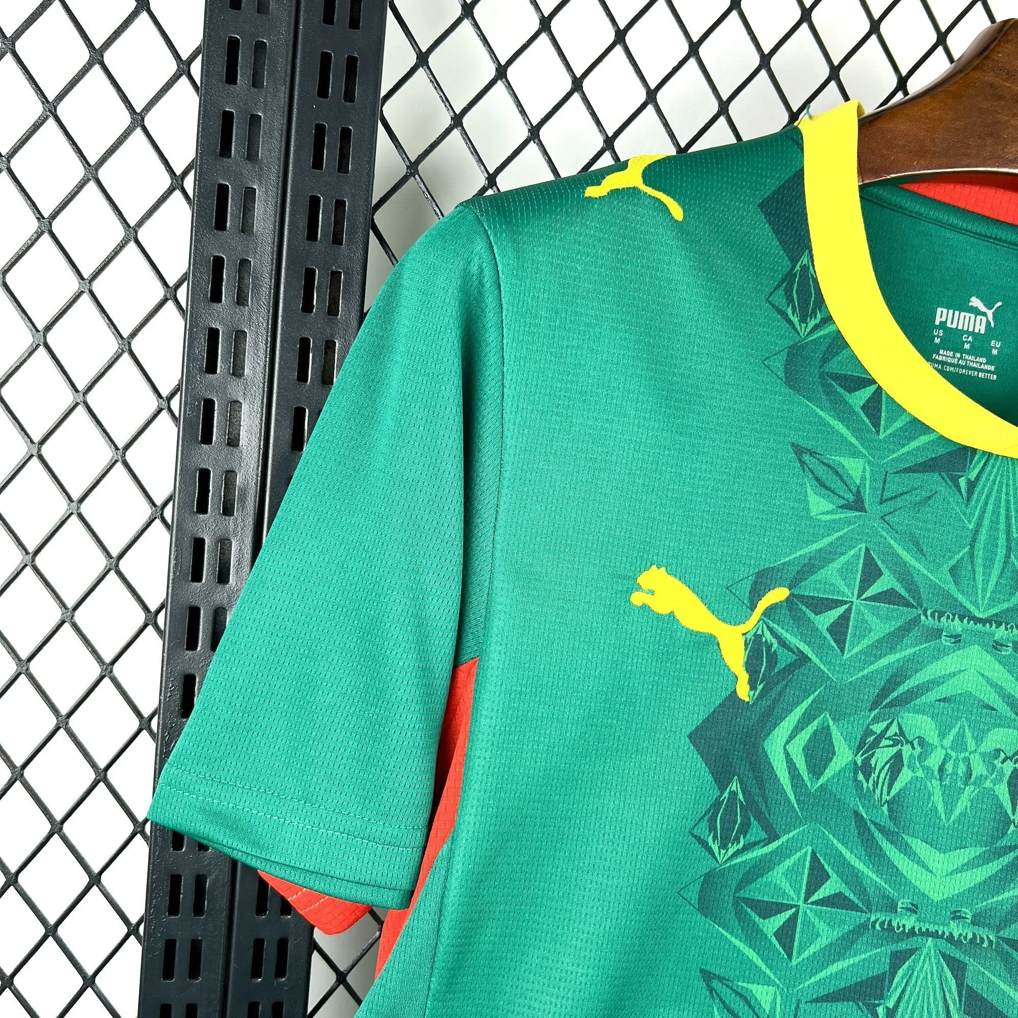 Detalle de la manga verde con un patrón gráfico de inspiración cultural en colores amarillo y rojo.