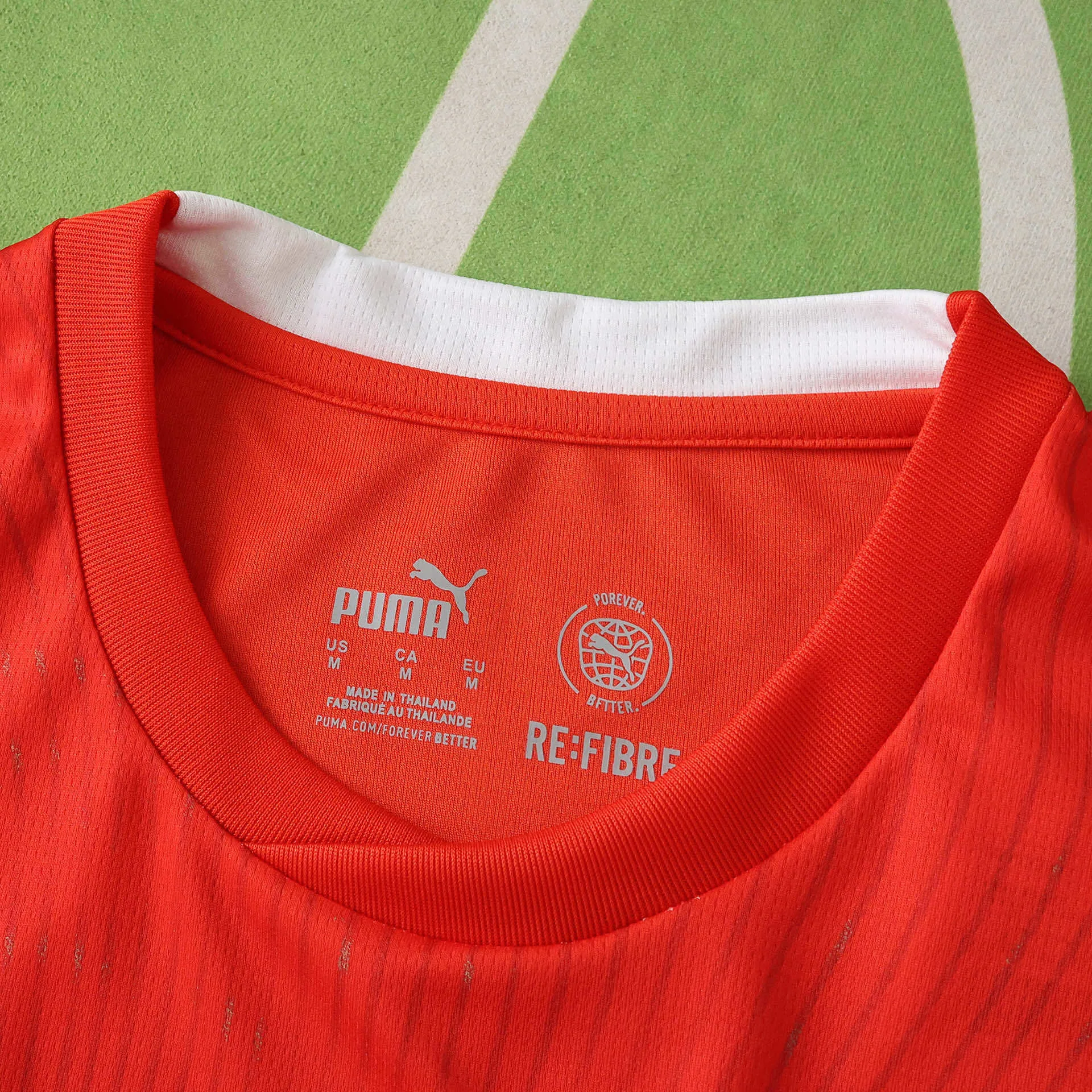 Vista frontal del cuello redondo rojo con ribete blanco y logotipos técnicos en el interior de la prenda.