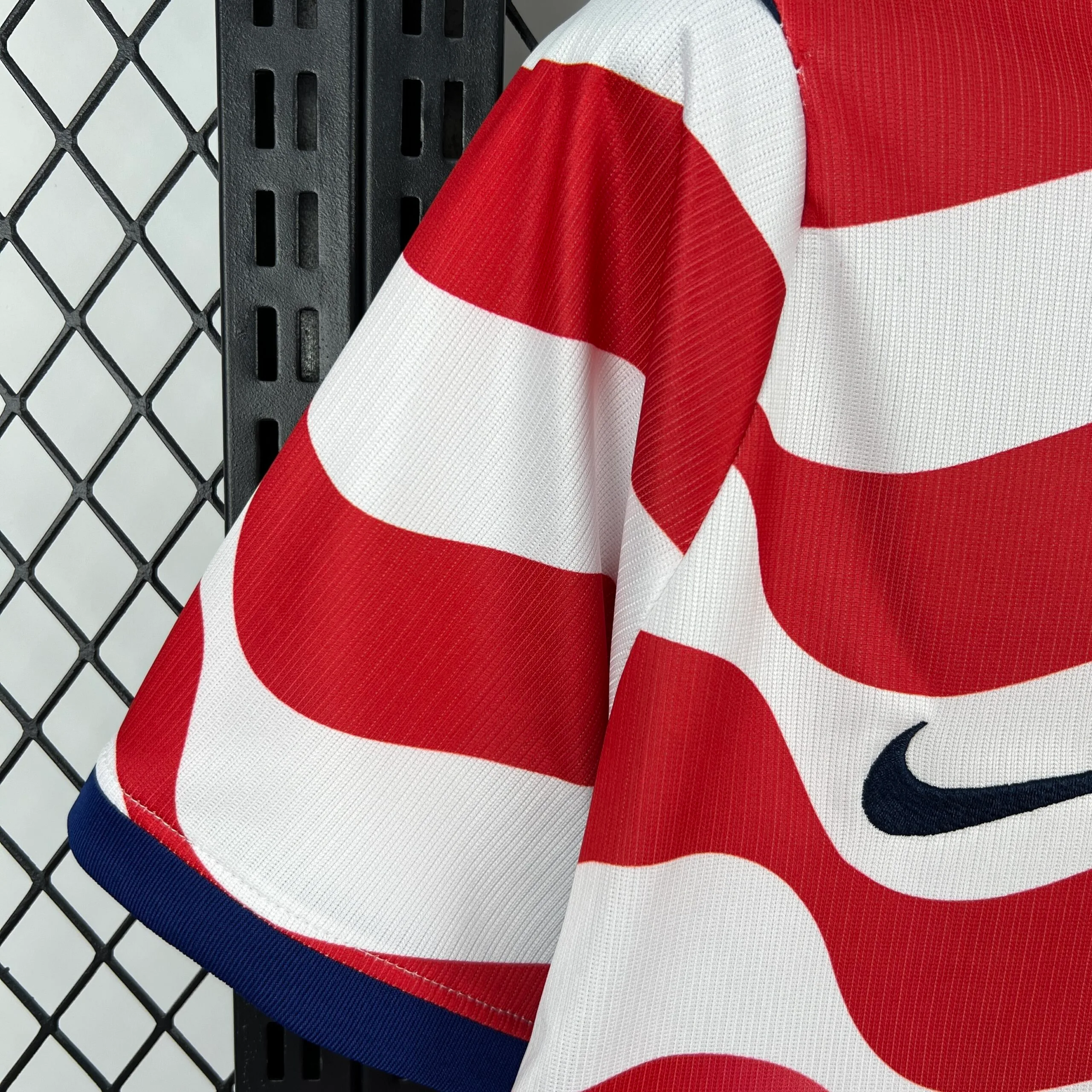 Primer plano de la manga en color rojo vibrante y detalle de las costuras de la camiseta de Estados Unidos.