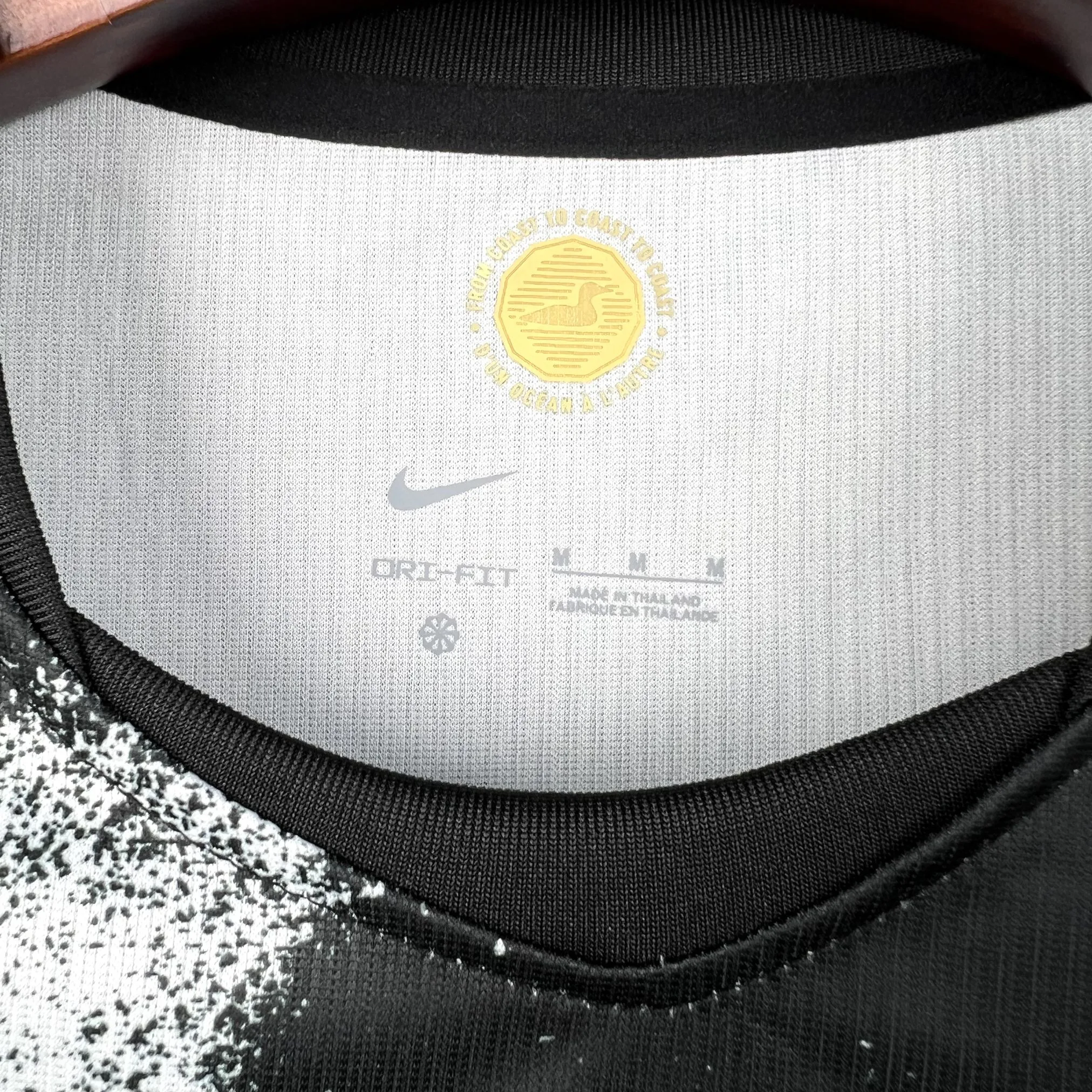 Detalle del cuello redondo bicolor en rojo y blanco con logotipos de tecnología impresos en el interior.