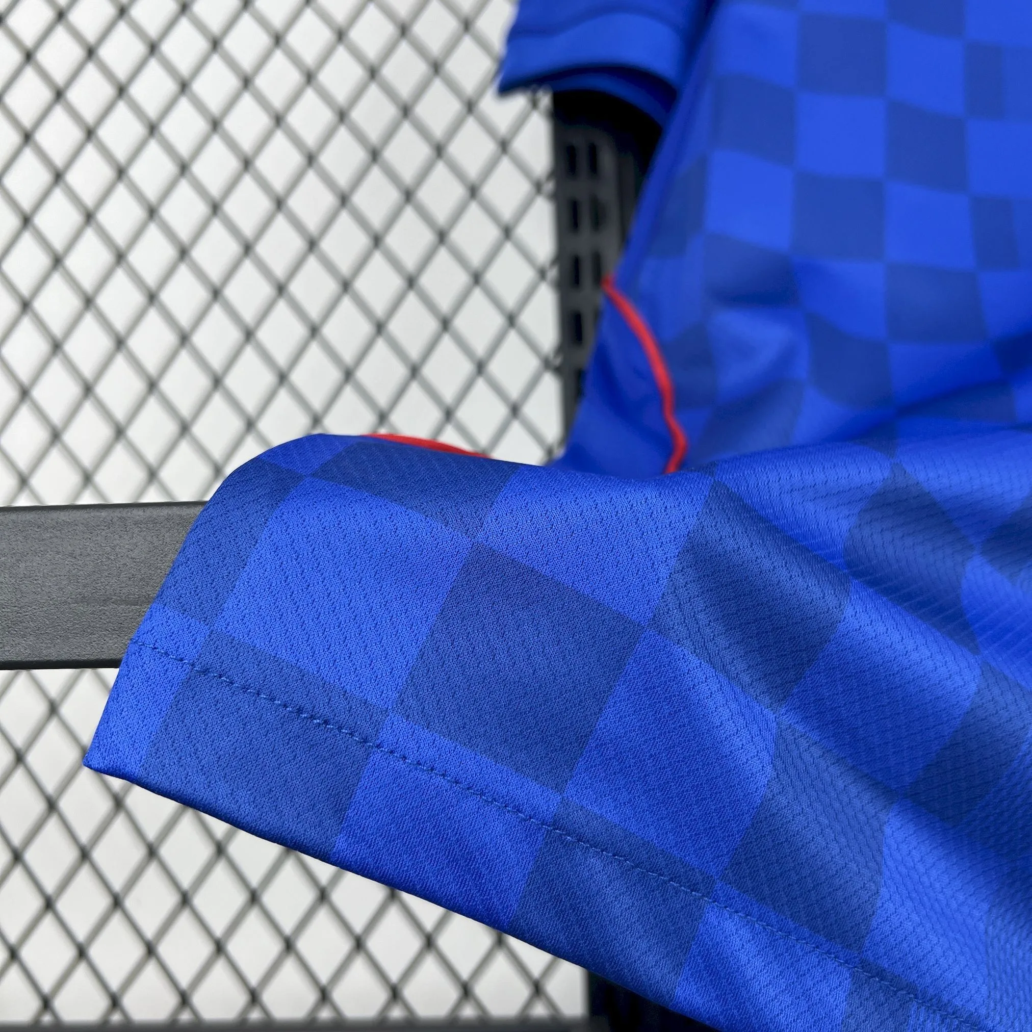 Detalle del acabado inferior de la camiseta y la textura del tejido técnico transpirable.