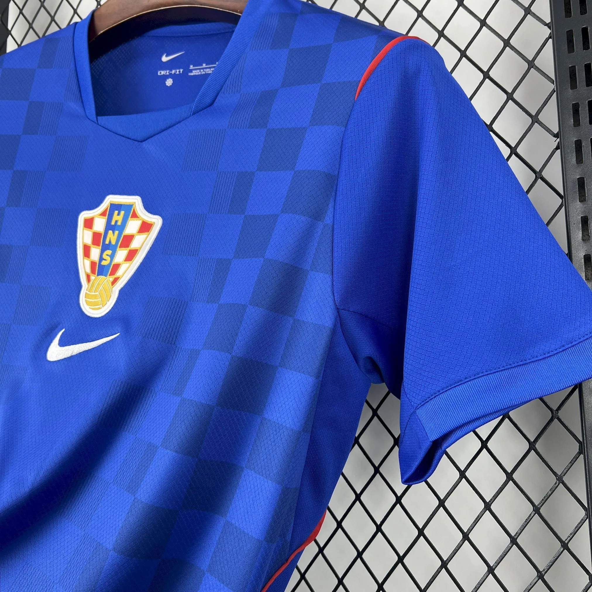 Detalle del borde de la manga con costuras reforzadas y el diseño geométrico en tonos azules.