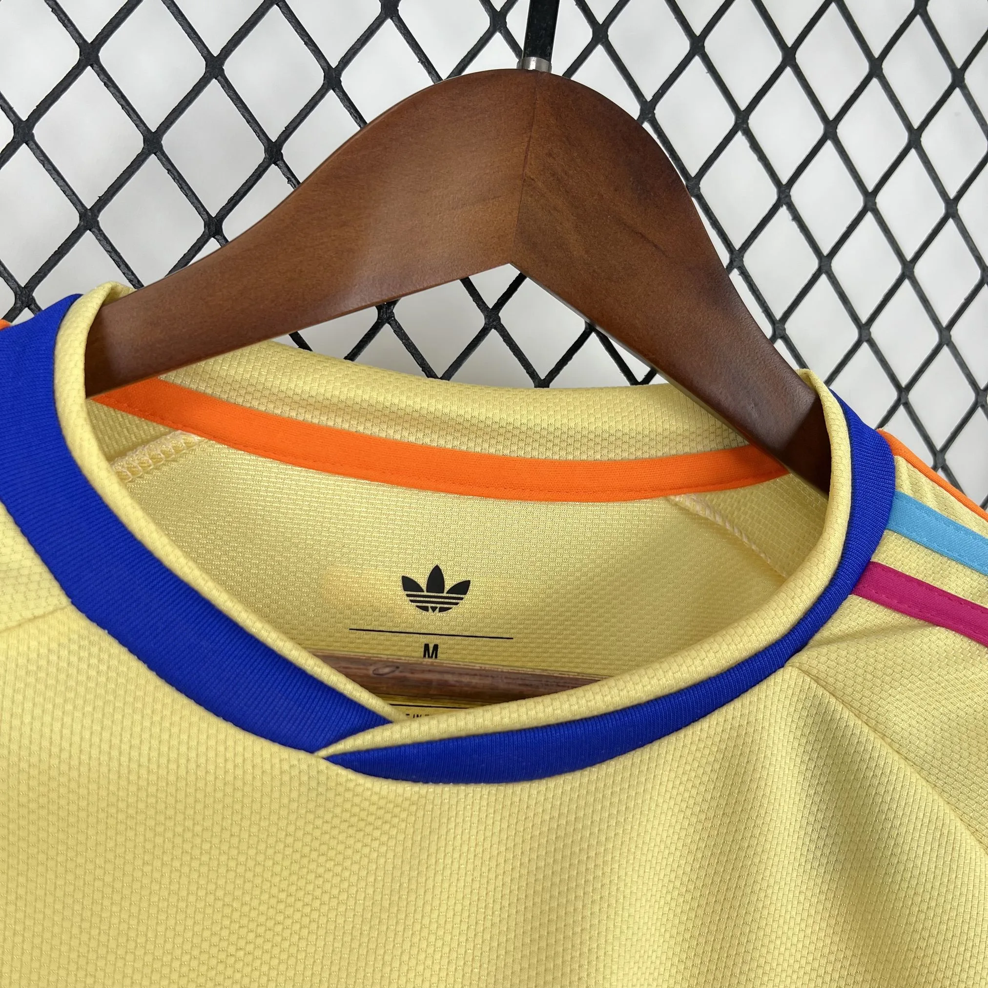 Detalle del cuello redondo blanco con finos vivos en amarillo y azul de la segunda equipación de Curazao.