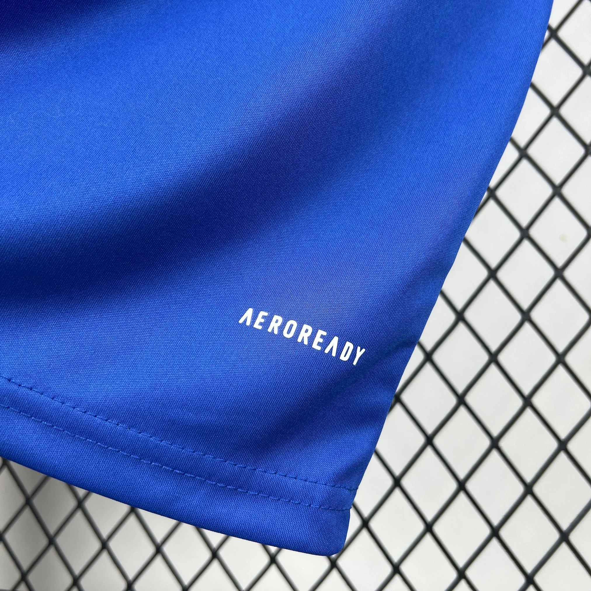 Detalle del acabado inferior de la camiseta de Curazao mostrando la textura del tejido técnico en color azul real.