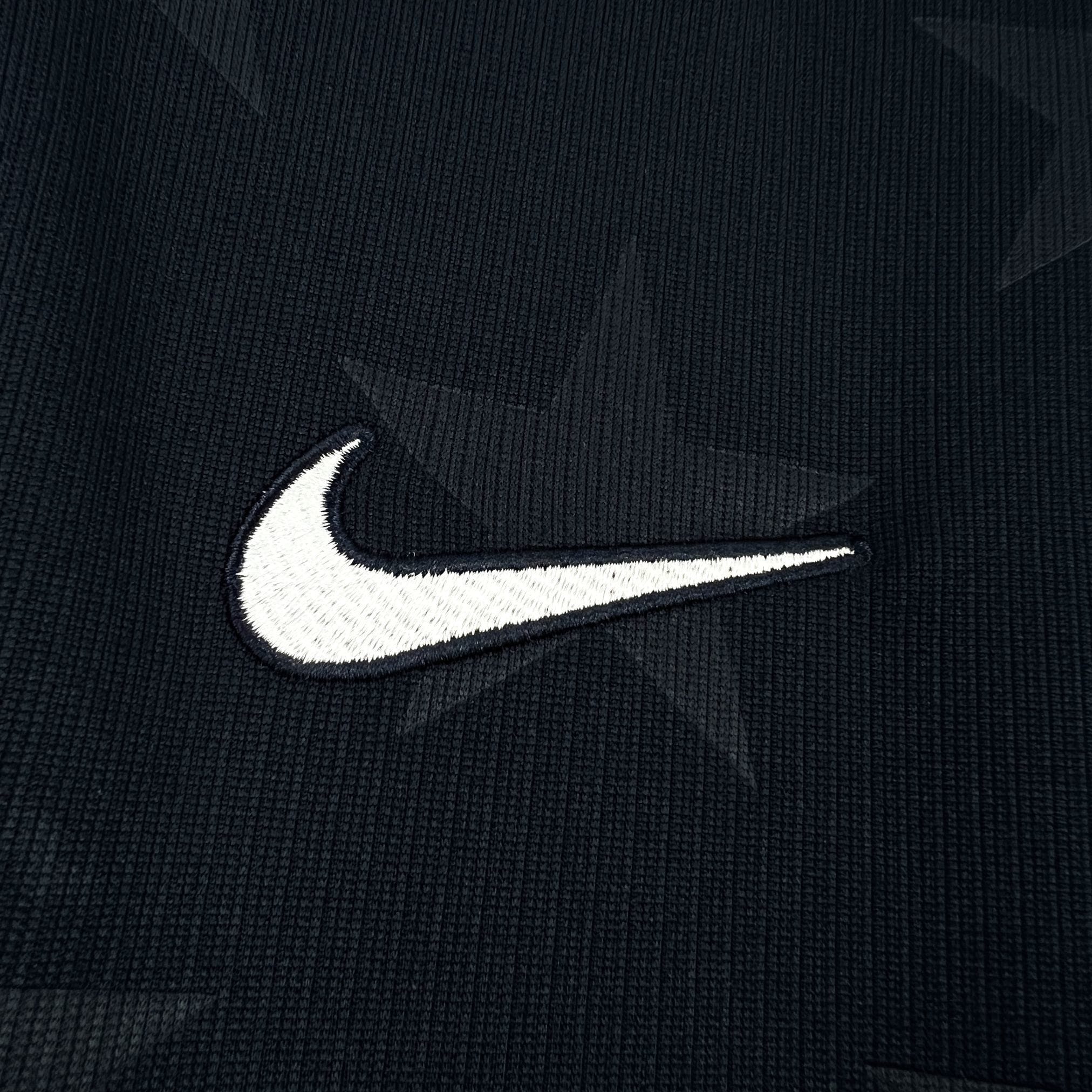 Detalle de logotipo decorativo bordado en color blanco sobre el pecho de la camiseta de Estados Unidos.