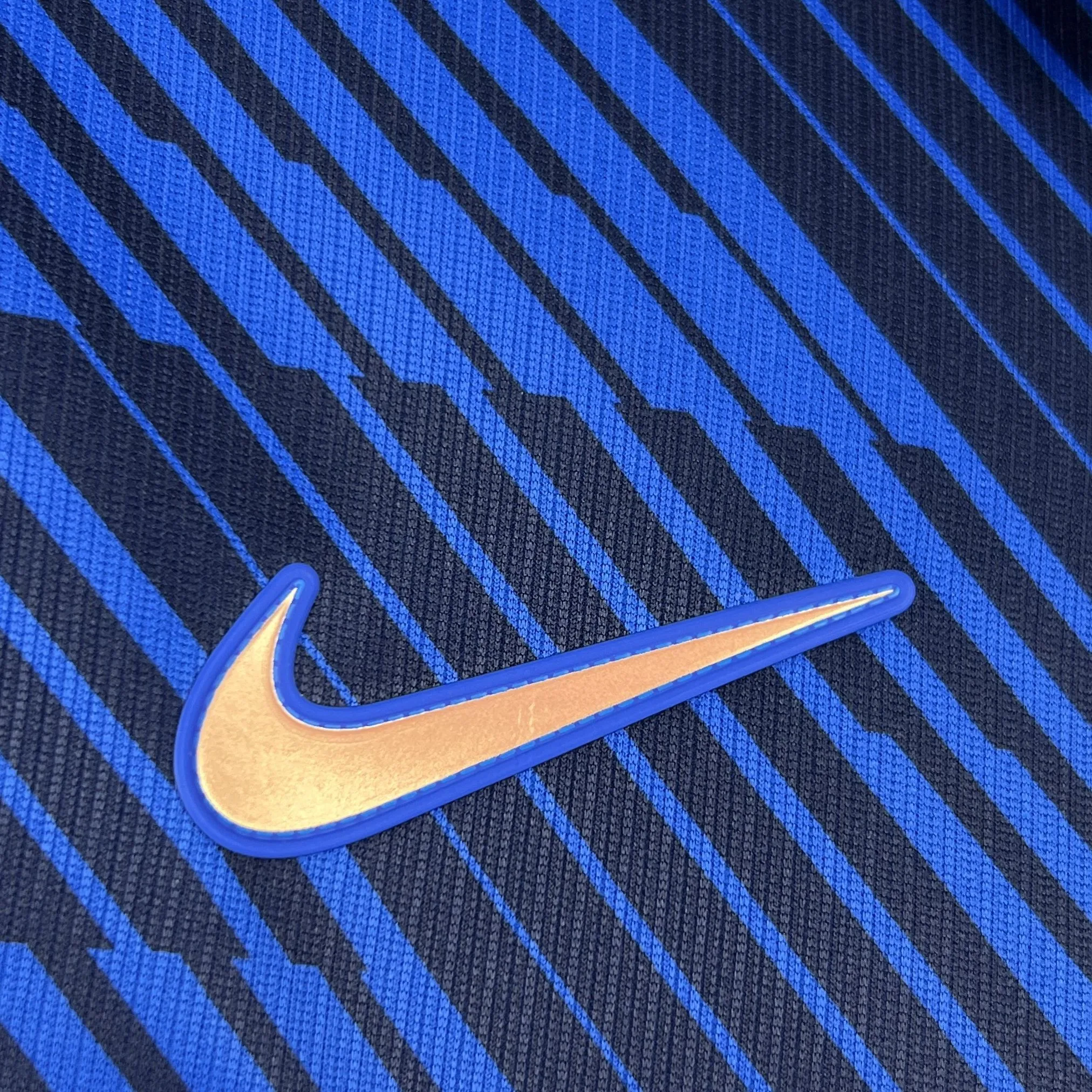 Primer plano de elemento decorativo bordado en color dorado sobre el pecho de la camiseta de Francia.