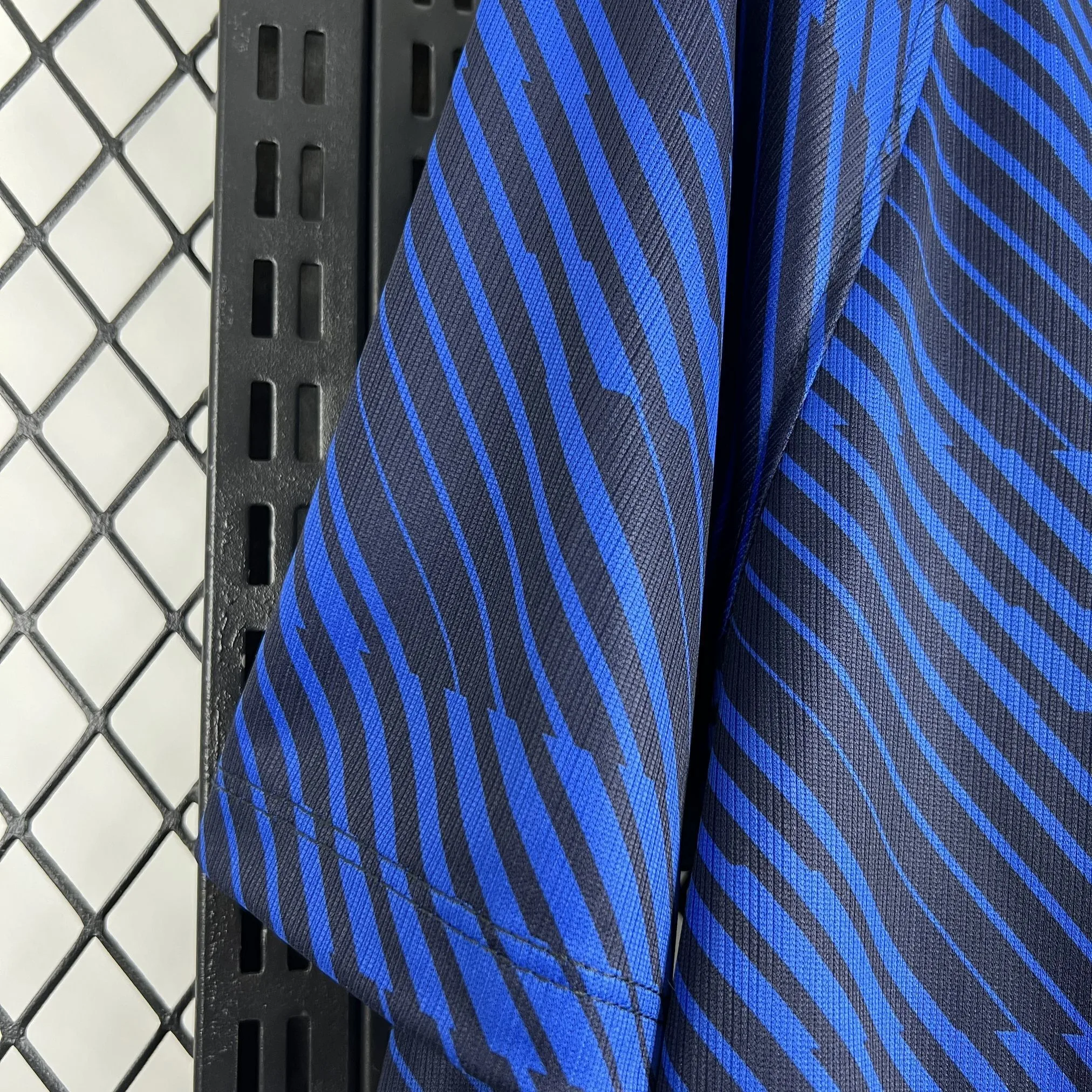 Detalle de la manga azul con remate de franjas elásticas en los colores de la bandera nacional francesa.