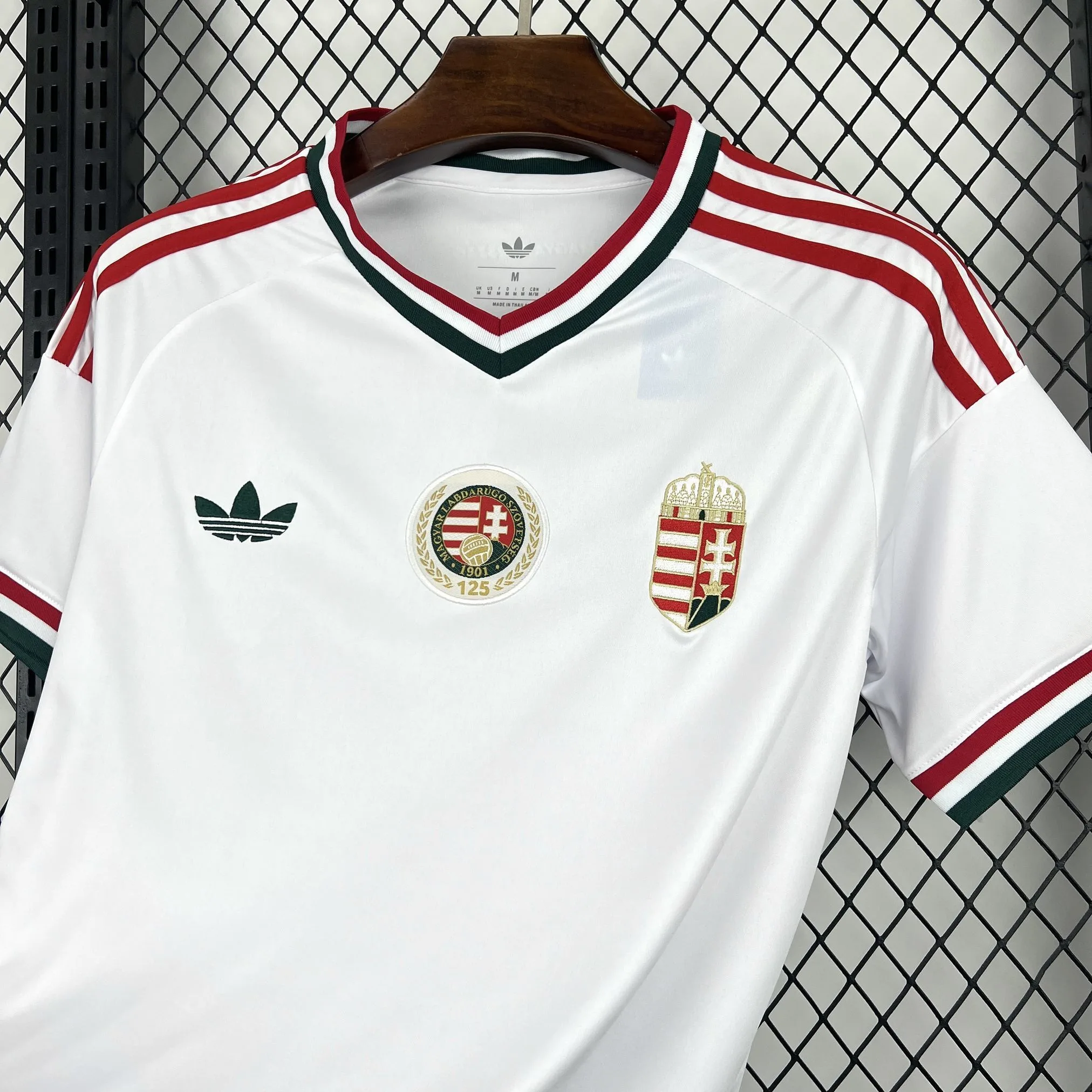 Imagen frontal completa de la camiseta de Hungría visitante con el diseño blanco y detalles en rojo y verde.