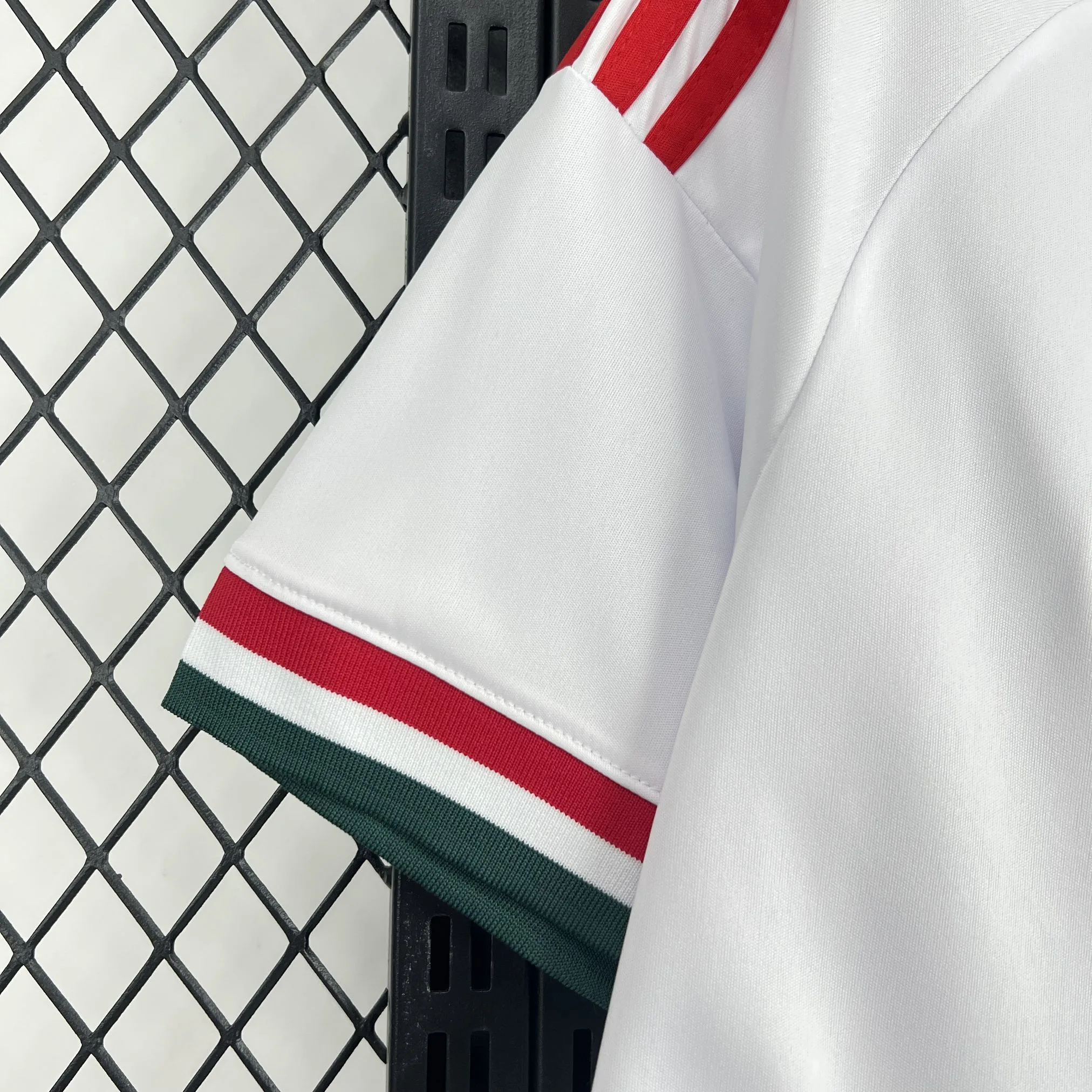 Detalle de la manga blanca con un panel degradado en los colores rojo y verde de la bandera húngara.