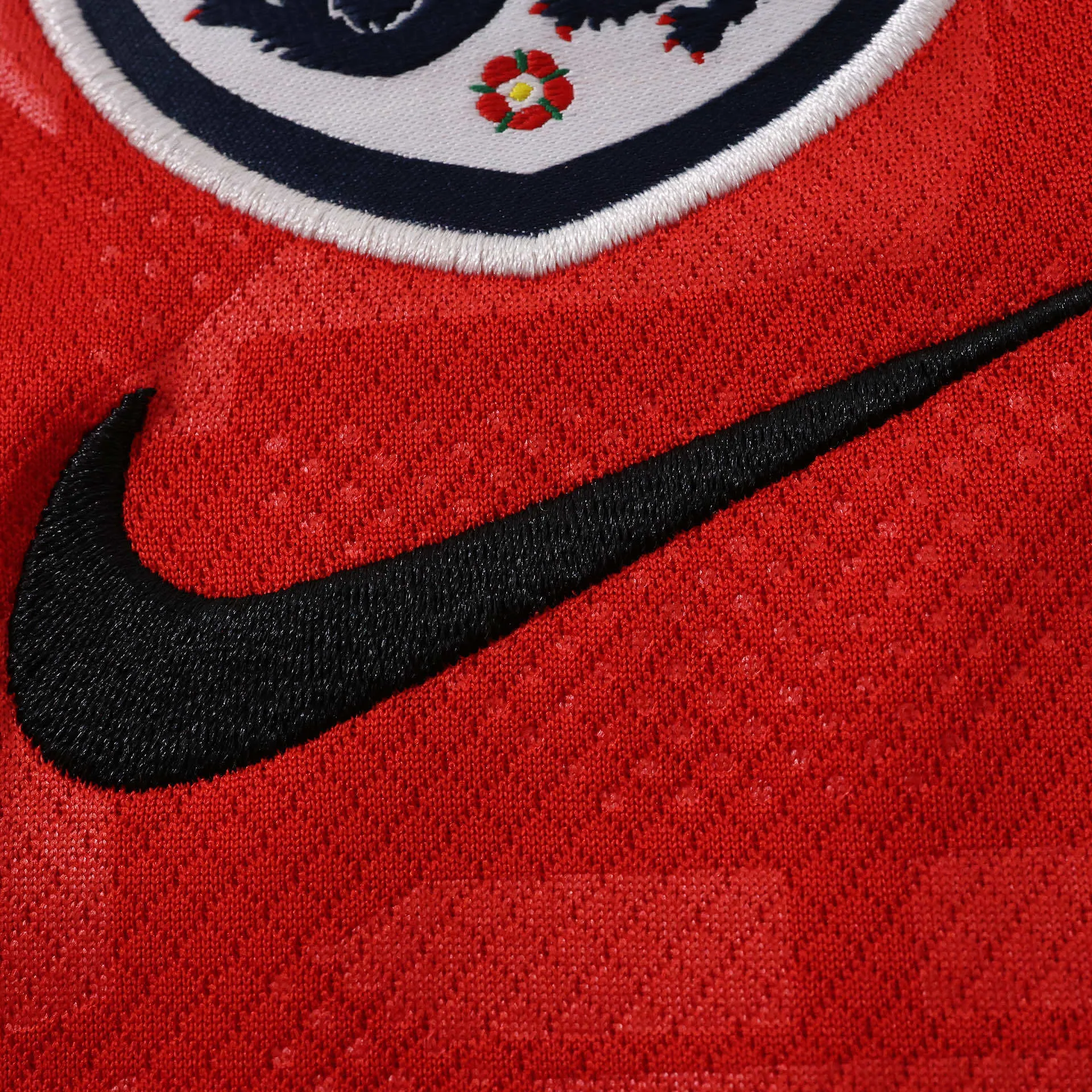 Detalle decorativo bordado en color dorado sobre el tejido técnico de la equipación visitante de Inglaterra.