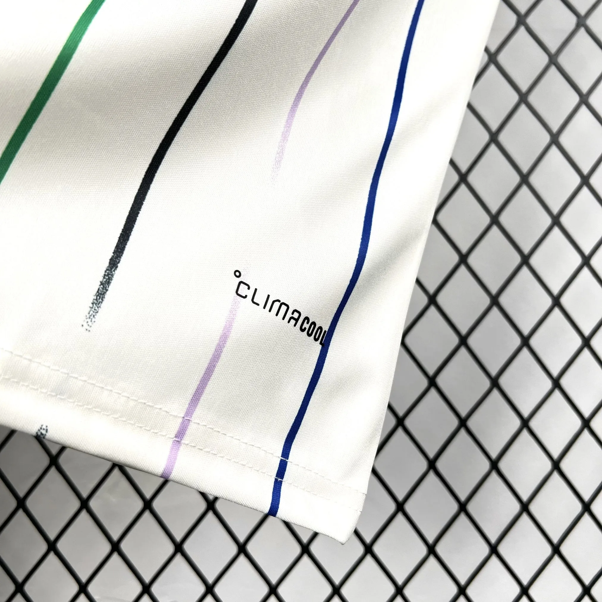 Detalle del lateral inferior de la camiseta blanca de Japón mostrando el patrón de líneas dinámicas en color gris.