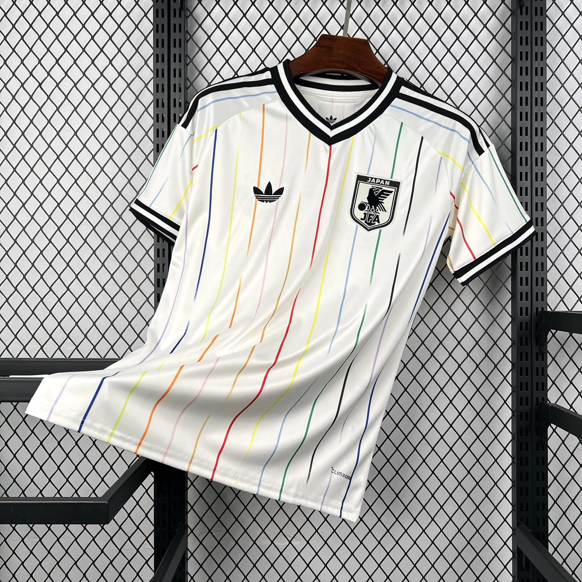 Imagen frontal completa de la camiseta de Japón visitante 2026, diseño blanco con gráficos laterales de llamas o líneas fluidas.